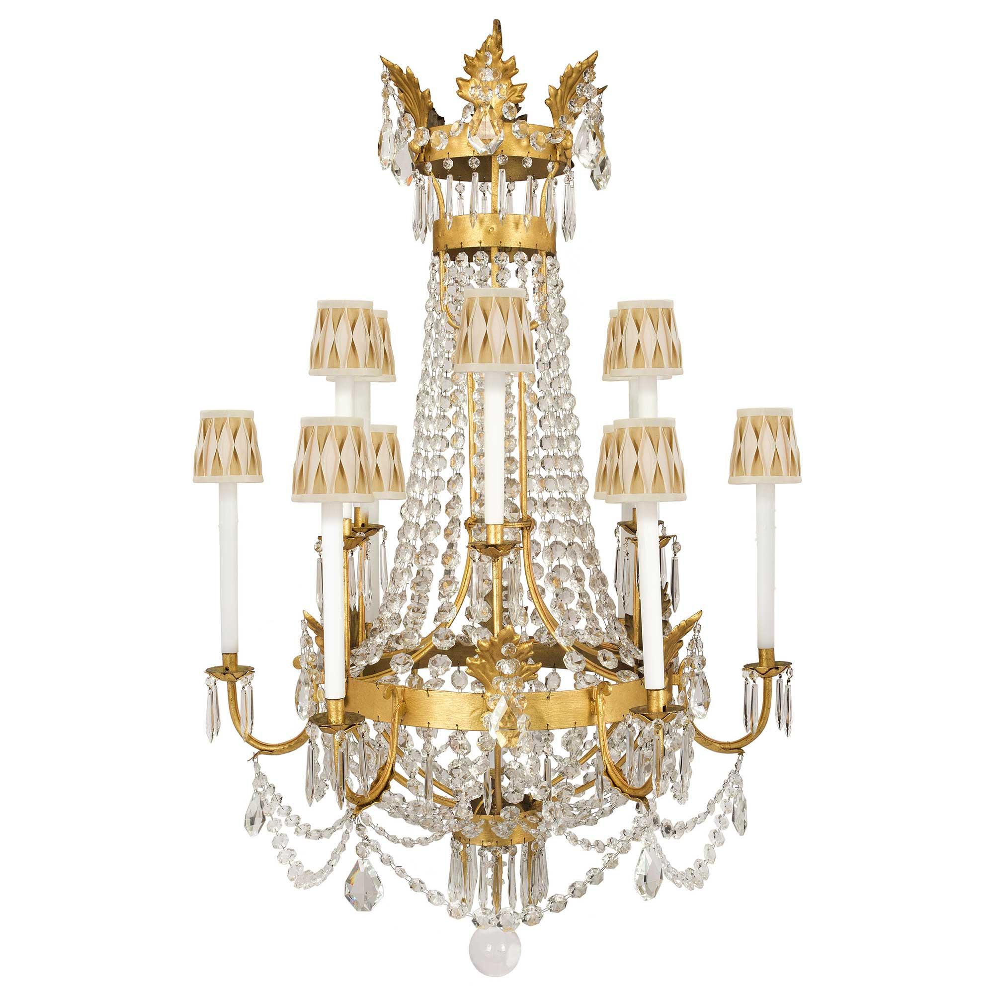 A fabulous pair of Italian 19th century Baccarat crystal and gilt iron twelve light chandelier. Each chandelier is centered by a beautiful solid crystal ball amidst most decorative prism shaped cut crystal pendants. Above beautiful circular cut