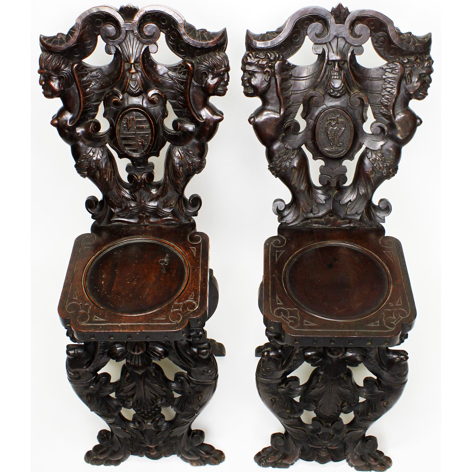 A fine pair of Italian 19th century Baroque Revival style carved walnut Sgabello figural side-chairs, each backrest with carvings of winged male figures, the base with female figures, raised on with paw feet, Florence, circa 1880.

Measures: