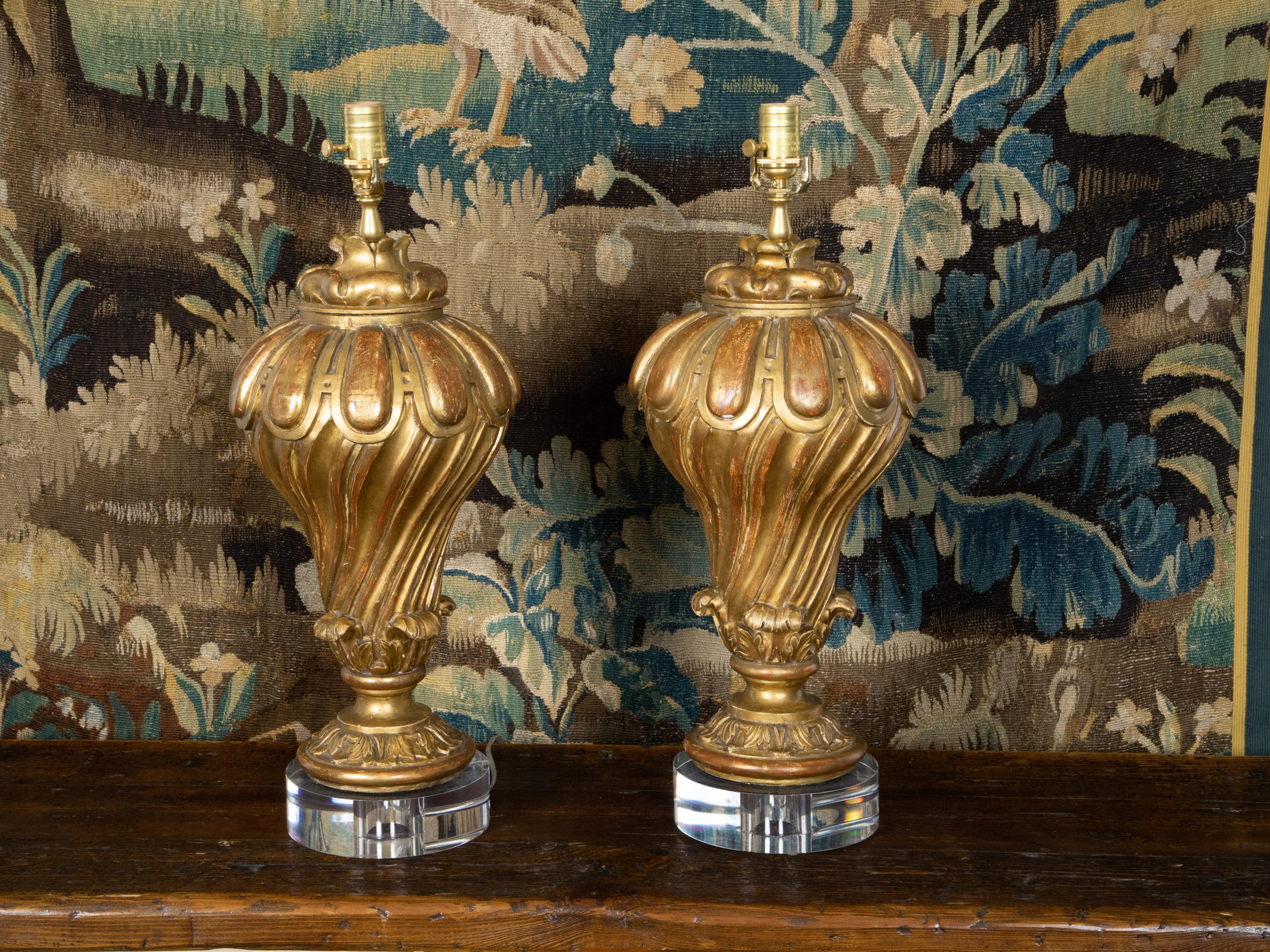 Lucite Paire de fragments de bois doré sculptés italiens du 19ème siècle transformés en lampes sur lucite en vente