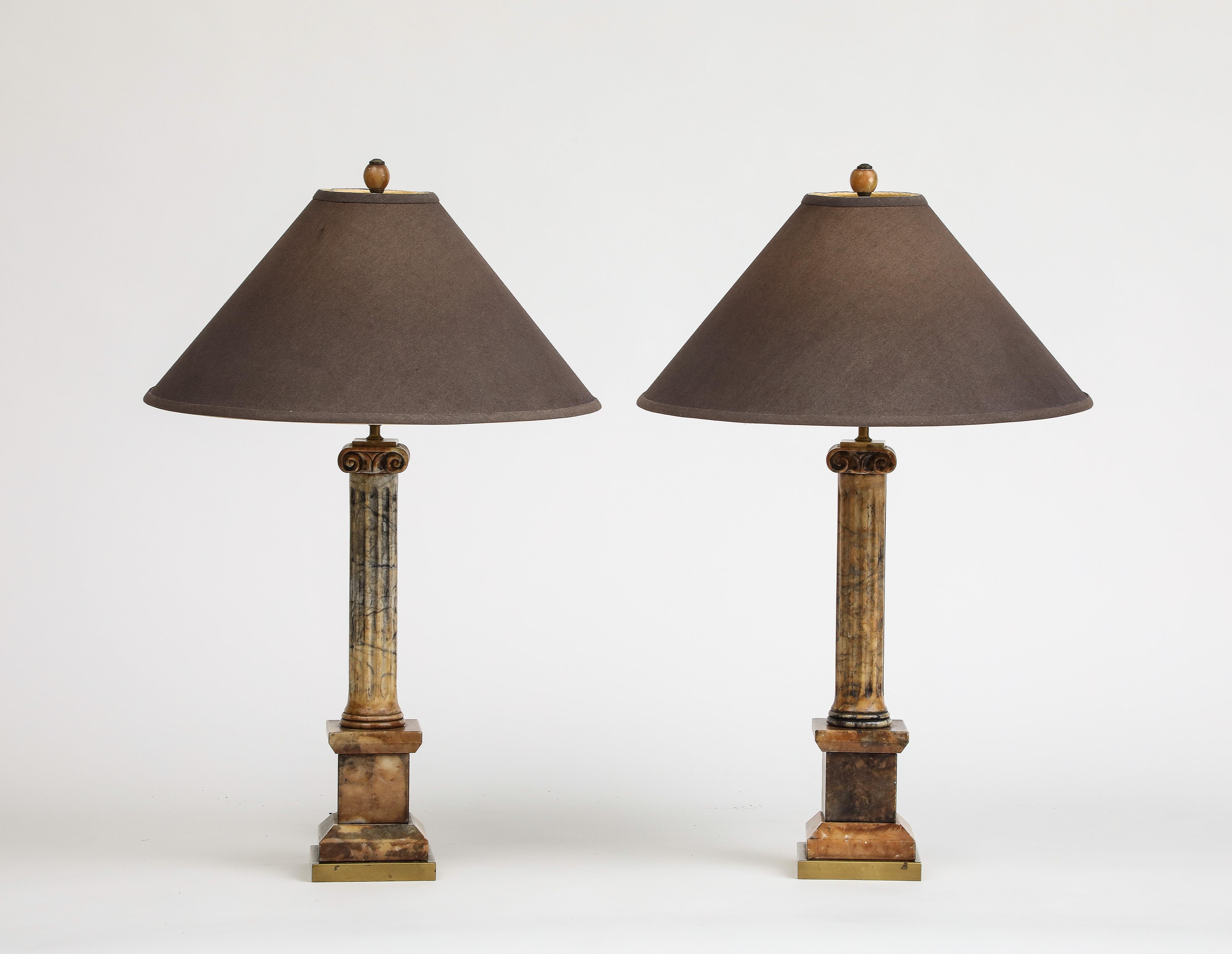 Pair of Italian 19th Century marble table lamps, carved into columns sitting atop prominent marble pedestals, with tan linen cone lampshades. 1 socket per lamp. 