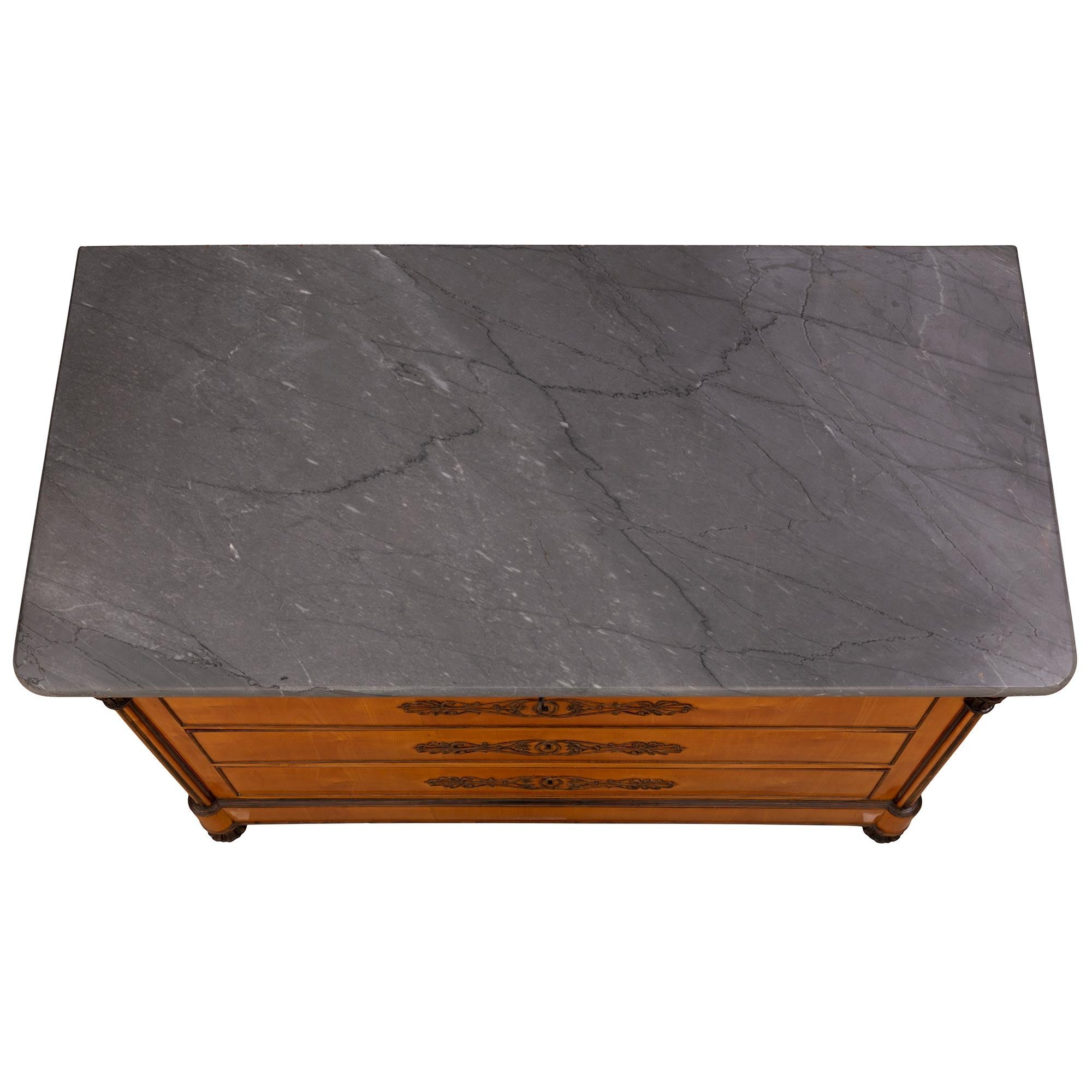 Un'impressionante coppia di commodes in ciliegio, betulla e marmo di St. Charles X del XIX secolo. Ciascuna cassettiera a quattro cassetti è dotata di eleganti piedini a sfera e di una bella fascia foliata in betulla patinata. Sopra il fregio dritto