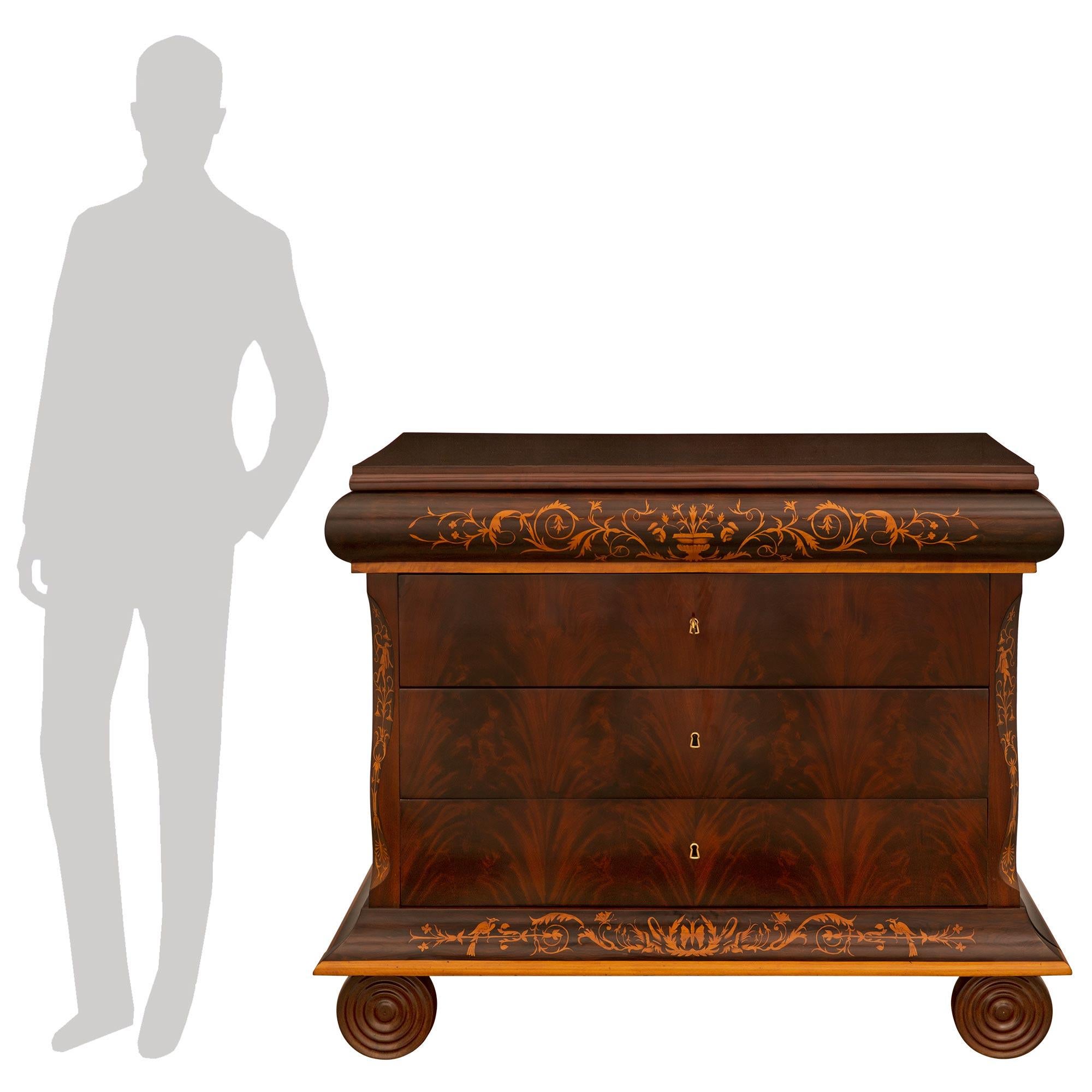 A stunning pair of Italian 19th century Charles X period Mahogany and Maplewood inlaid commodes. Each five drawer commode is raised on unique circular reeded front legs below the bottom concave shaped drawer with a maple bull nose band and inlayed