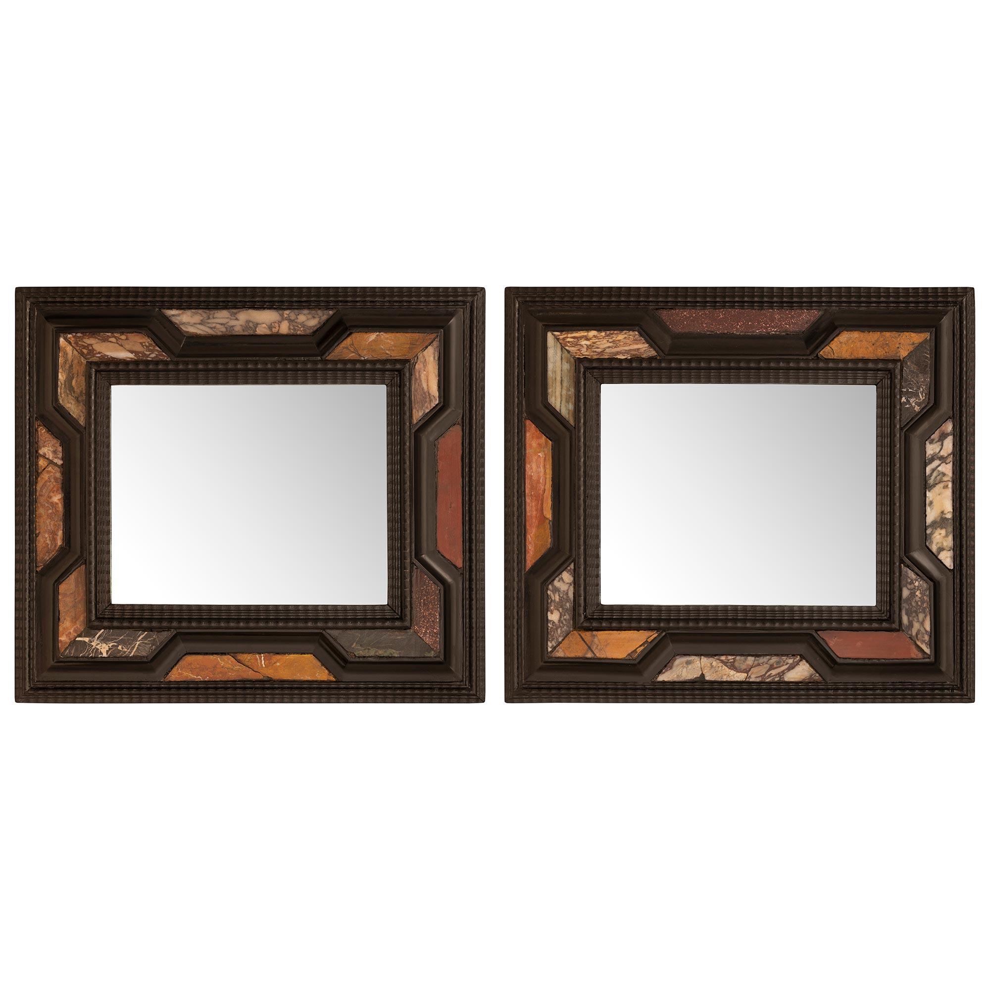 An exceptional pair of Italian 19th century Florentine st. ebonized Fruitwood and marble mirrors. Each mirror retains their original mirror plates framed within a most decorative mottled wrap around band with exceptional wave like designs. The outer