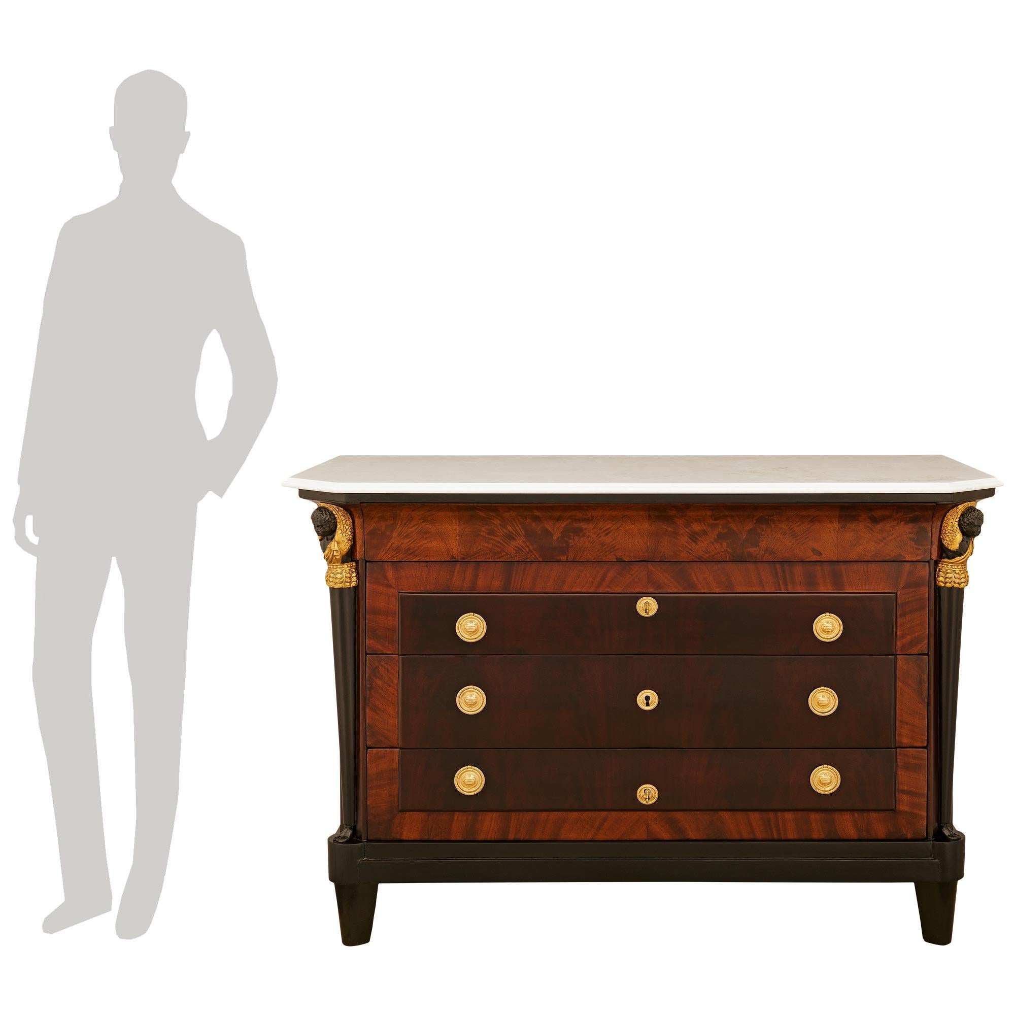 Una sensazionale ed elegantissima coppia di commodes neoclassiche italiane dell'inizio del XIX secolo in legno di frutta ebanizzato, mogano, legno dorato e ormeggio. Questa eccezionale coppia di cassapanche è sollevata da gambe cilindriche