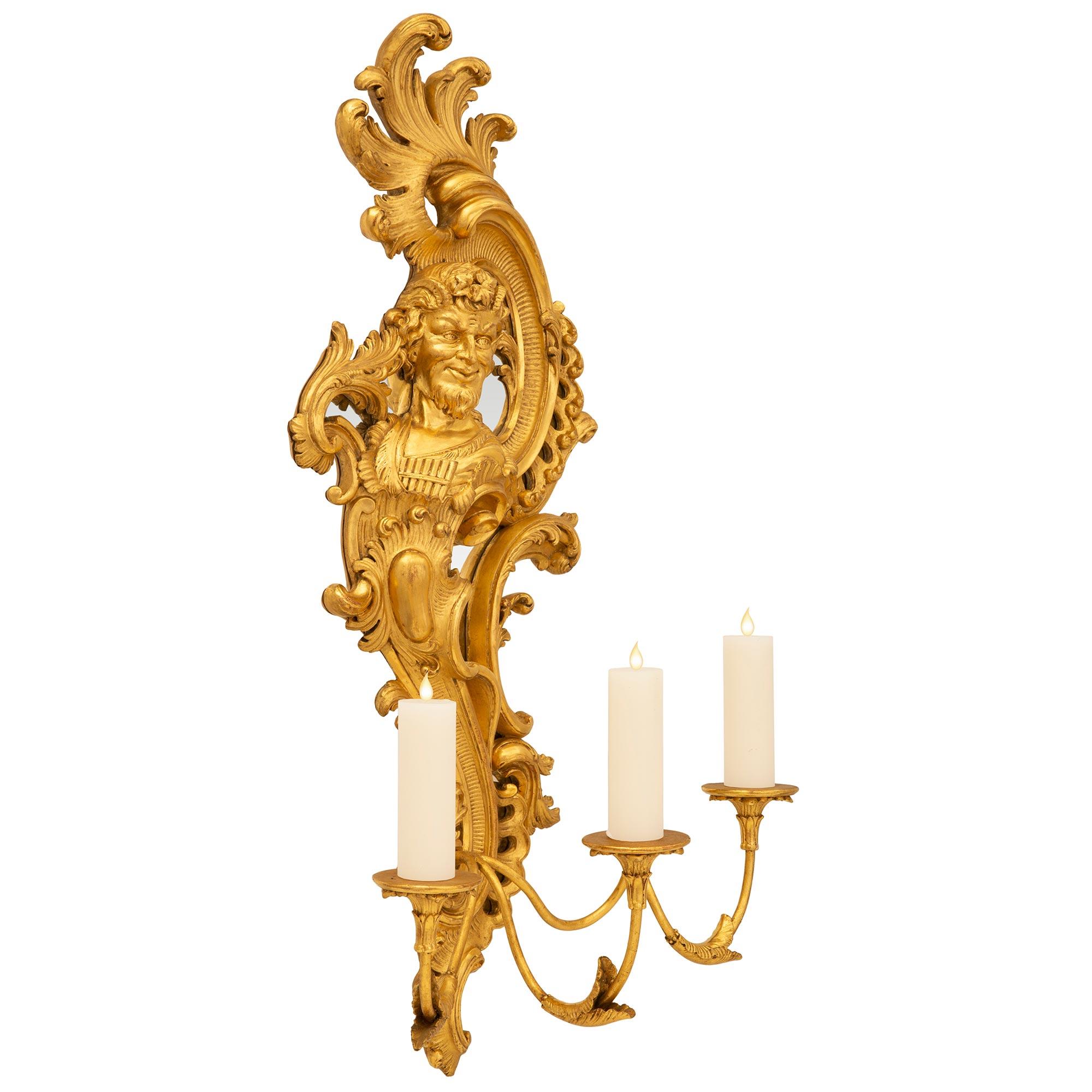 A spectacular and very high quality pair of Italian 19th century giltwood and mirror three arm sconces. With elaborate S scroll shapes and finely carved detailed busts of the nymph Syrinx and Greek god Pan. At the bottom is an elegant C scroll