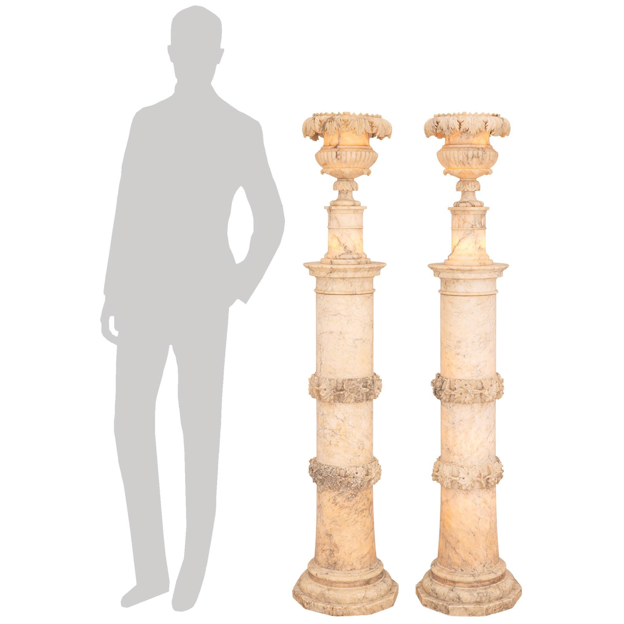 A truly stunning and most impressive pair of Italian 19th century illuminated Alabaster columns and urns. Each wonderfully electrified column is lit from within and is raised on a ten-sided plinth below a mottled band and the gracefully tapered