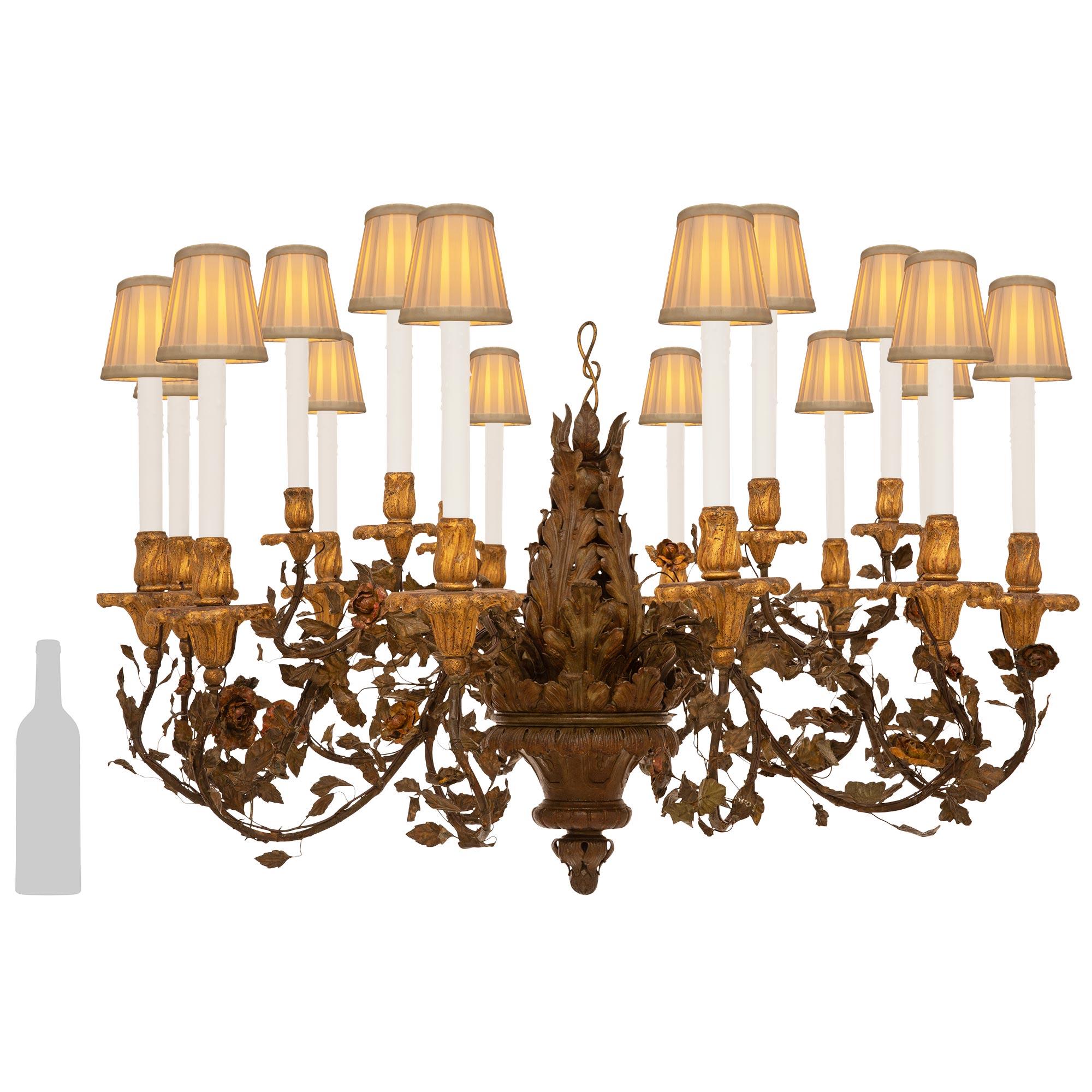 A very handsome and highly detailed pair of Italian 19th century Baroque st. Iron, Tole, Giltwood, and patinated Bronze chandeliers. Each stunning eighteen arm eighteen light chandelier is centered by an acorn bottom finial with acanthus leaves