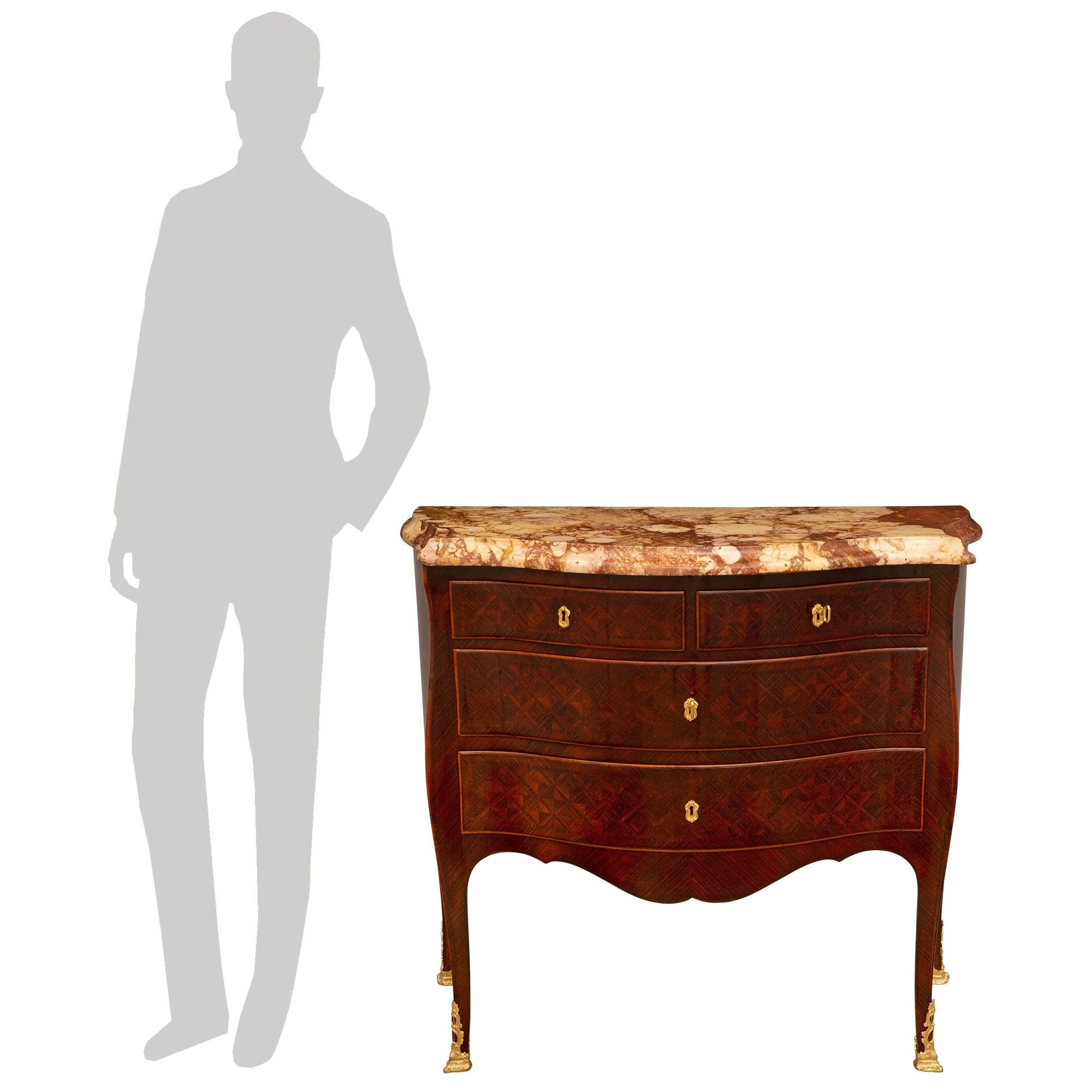 A stunning and extremely decorative pair of Italian early 19th century Louis XV st. Kingwood, ormolu and Brèche de Sicile marble commodes. Each four drawer chest is raised by elegant lightly curved legs with richly chased pierced fitted foliate