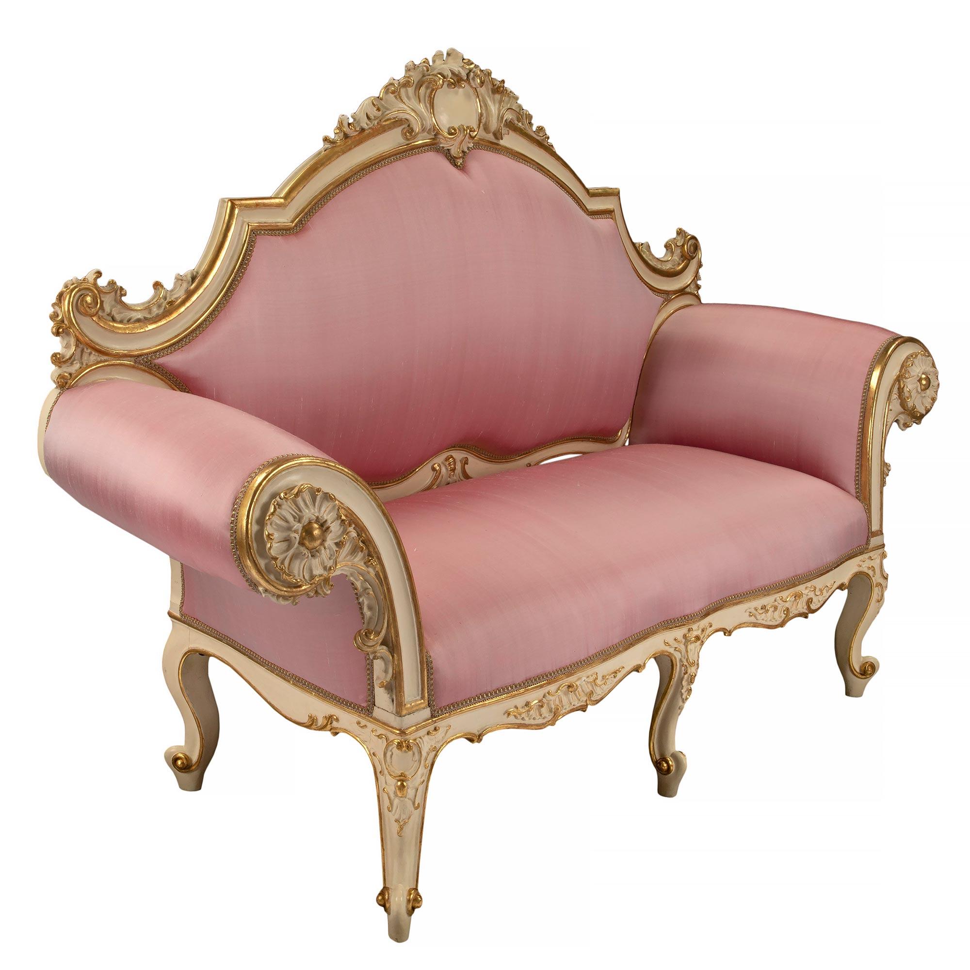 A stunning and unique pair of Italian 19th century Louis XV st. patinated and giltwood Venetian settees. Each settee is raised by elegant cabriole legs with finely carved foliate giltwood designs which extend along the scalloped shaped frieze with