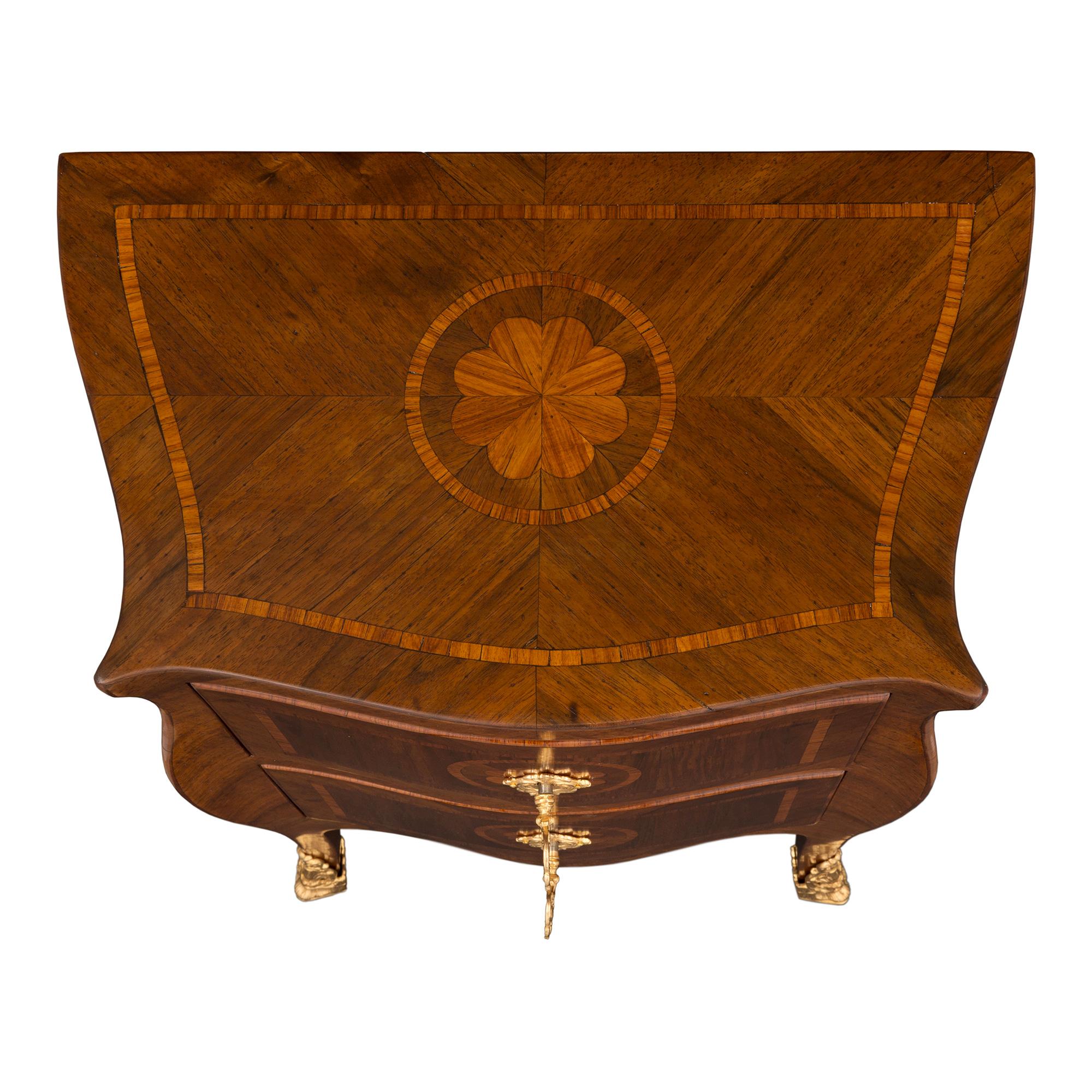 An exceptional pair of Italian 19th century Louis XV St. walnut, tulipwood and ormolu Genovese commodes. Each chest is raised by handsome lightly curved legs with elegant pierced fitted ormolu sabots. Above the scalloped shaped frieze are two