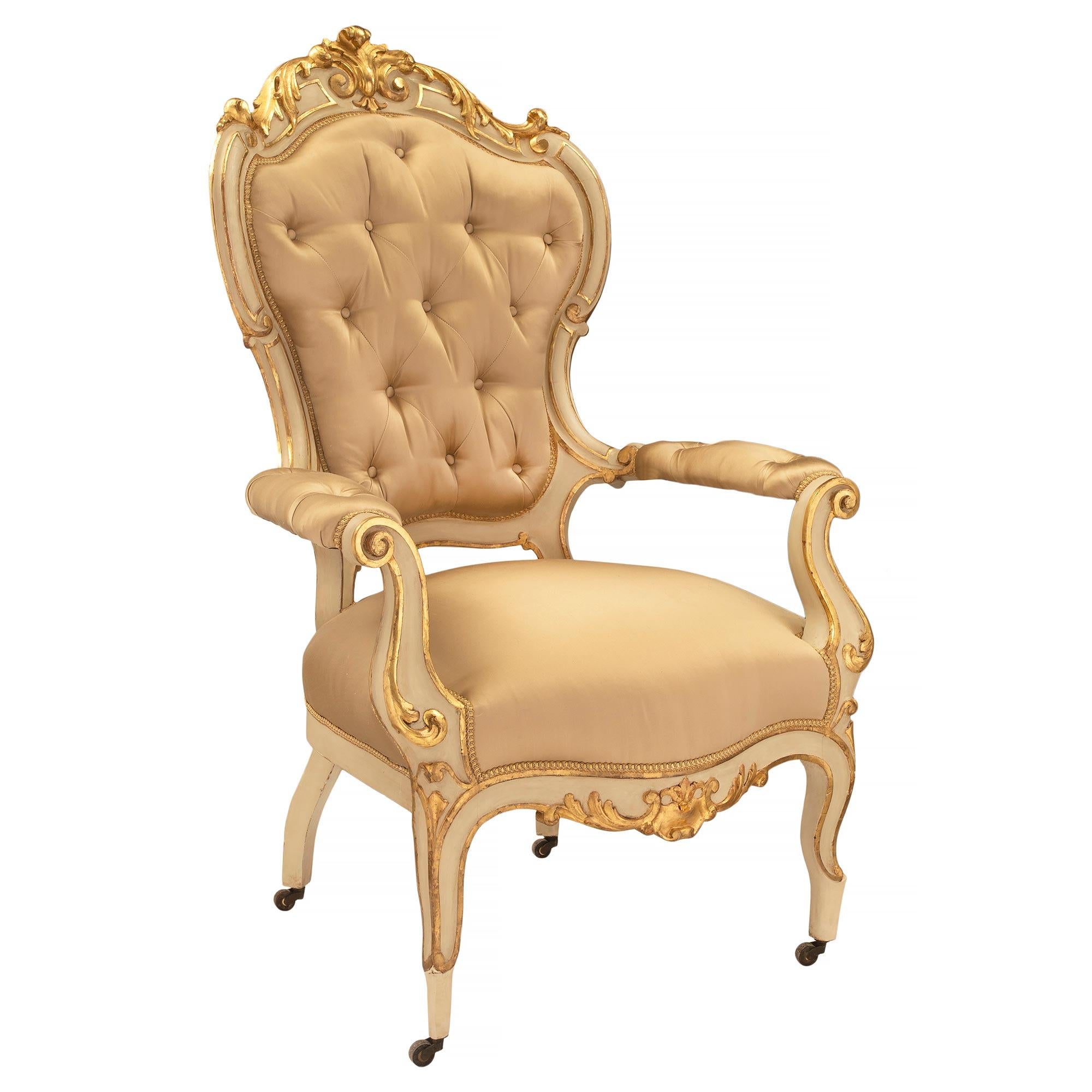 A unique and most decorative pair of Italian 19th century Louis XV st. patinated and giltwood armchairs. Each armchair is raised by their original caster and elegant patinated cabriole legs with fine giltwood fillets which extend up each leg and