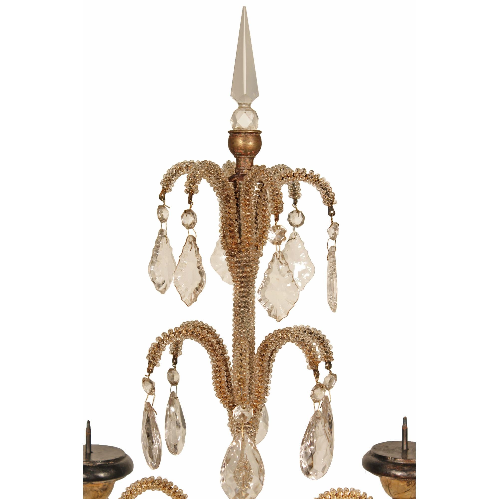 A sensational pair of Italian Louis XVI st. four arm candelabras. Each candelabra is raised by a faux painted marble square base. The mecca and patinated black urn supports the four 'S' scrolled beaded arms which are joined by glass swaging garlands