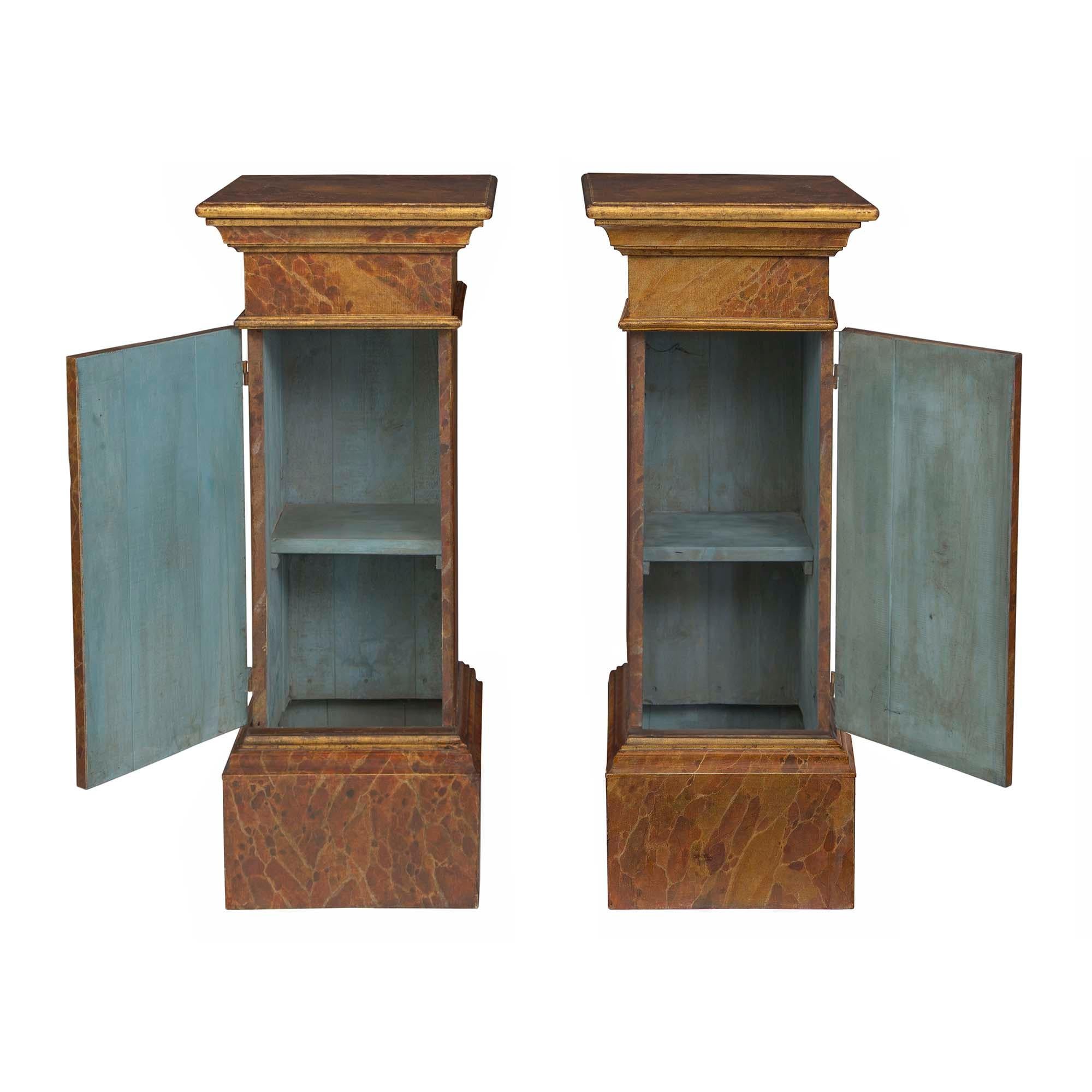 An extremely decorative pair of Italian 19th century Louis XVI st. faux painted and giltwood architectural column pedestals. Each pedestal is raised by a square base with a stepped design and a beautiful hand painted faux Bréche d'Alep finish