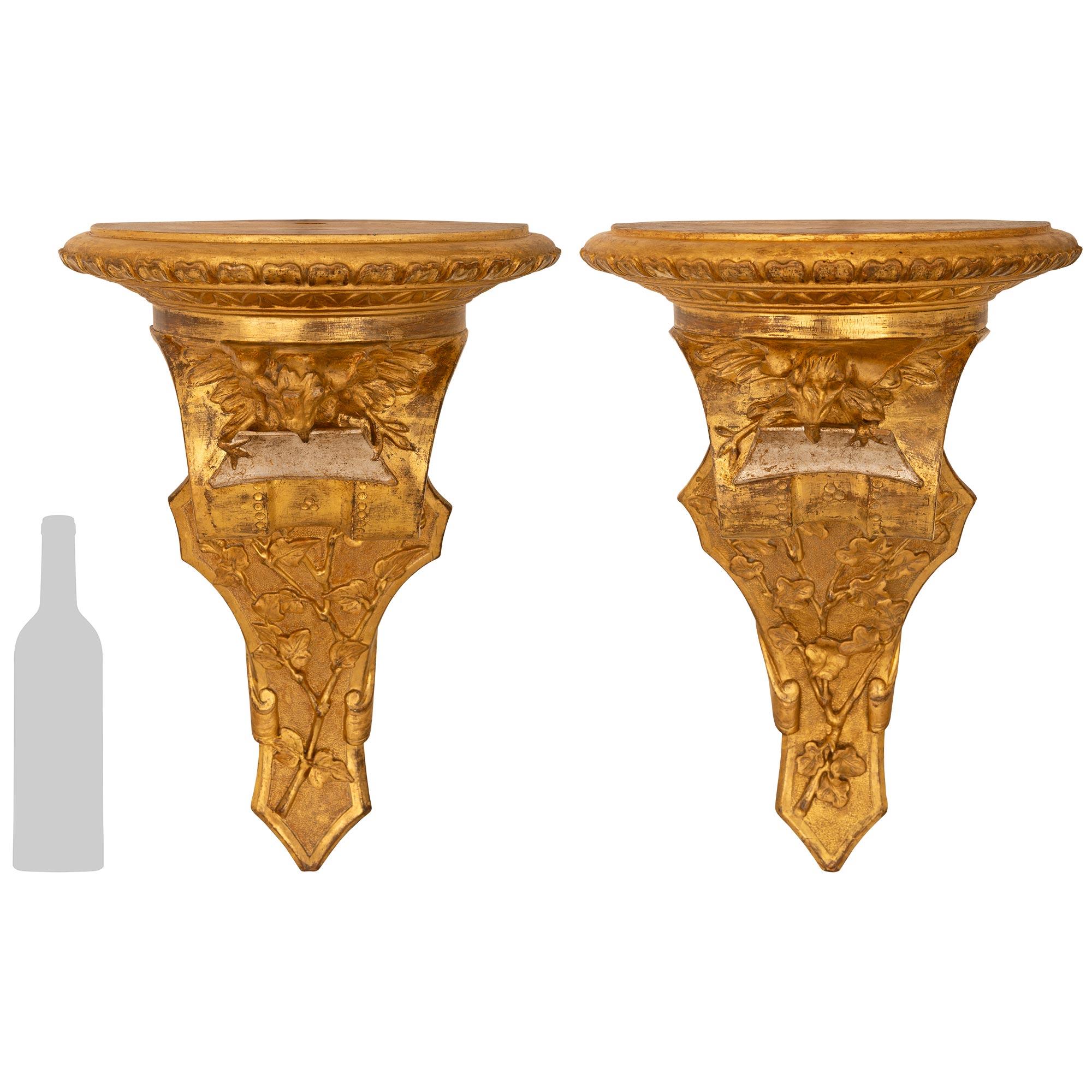 A wonderful and most decorative pair of Italian 19th century Louis XVI st. Giltwood and Mecca wall brackets. Each richly detailed wall bracket is centered by stunning foliate carvings leading up to handsome Eagles holding Mecca plaques in their