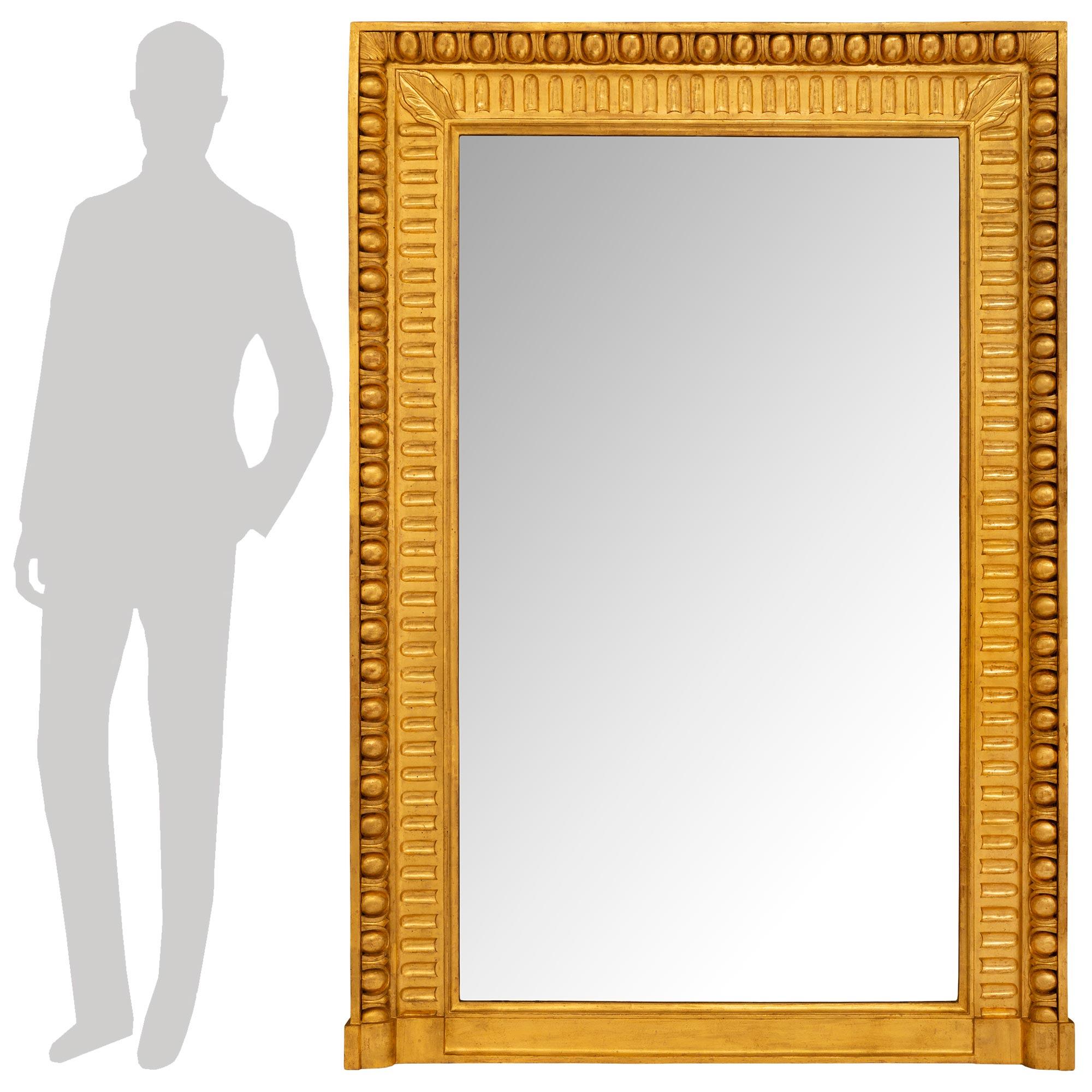 Belle paire de miroirs rectangulaires en bois doré de style Louis XVI italien du XIXe siècle. Les plaques de miroir originales sont encadrées d'un impressionnant motif cannelé à l'intérieur et d'une bordure extérieure en forme d'œuf et de dard. Les