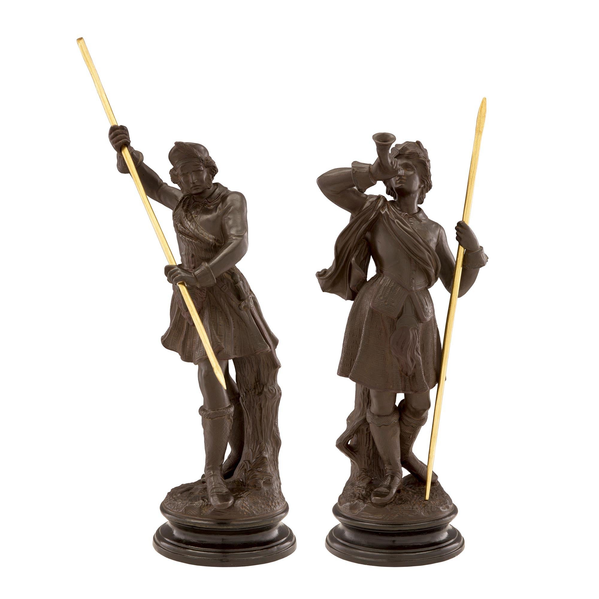 A charming and finely detailed true pair of Italian 19th century Louis XVI st. terra cotta and giltwood statues. Each statue is raised by an elegant circular mottled base where each personage above stands on a ground designed base. To the left is a