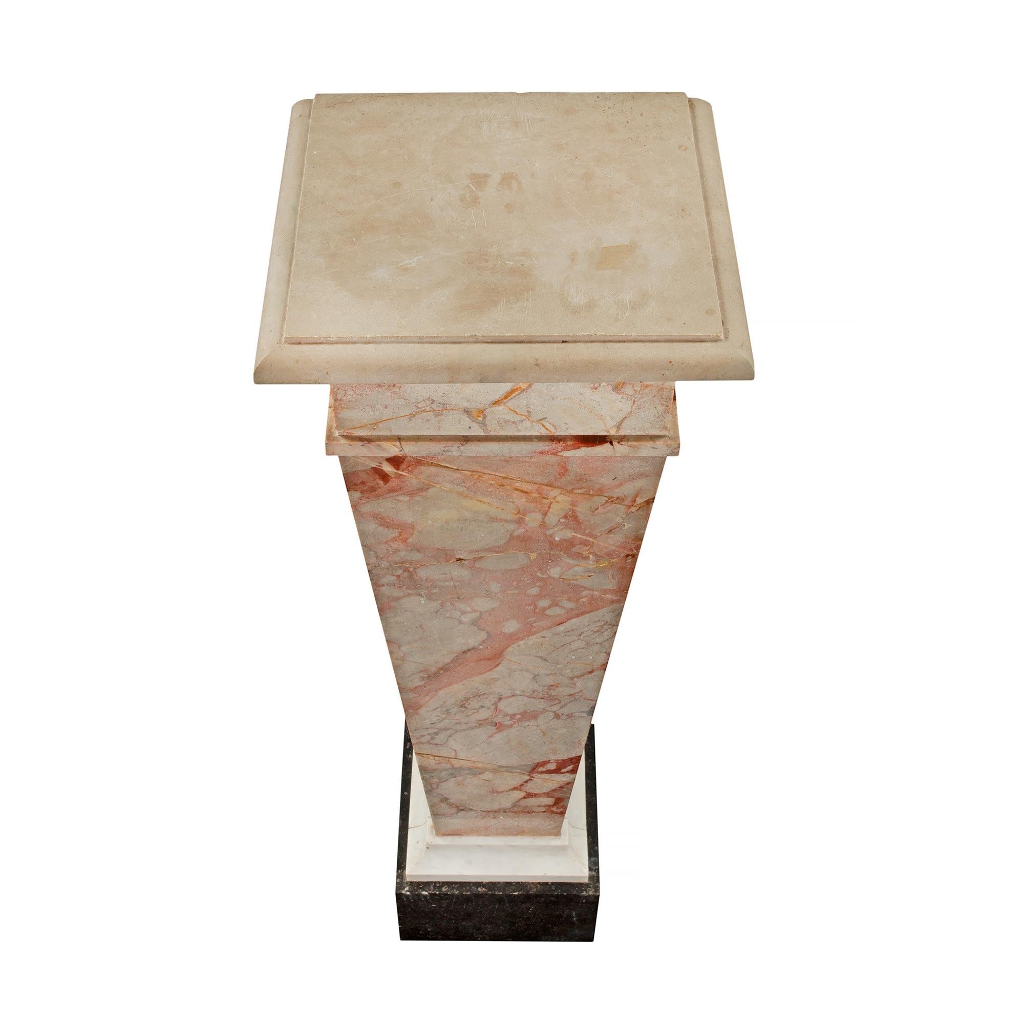A handsome pair of Italian 19th century Louis XVI st. marble pedestals. The pair are raised by an impressive and thick Black Belgian marble plinth below a White Carrara marble socle. Above is the tapered fut in Giallo Antico marble. The top
