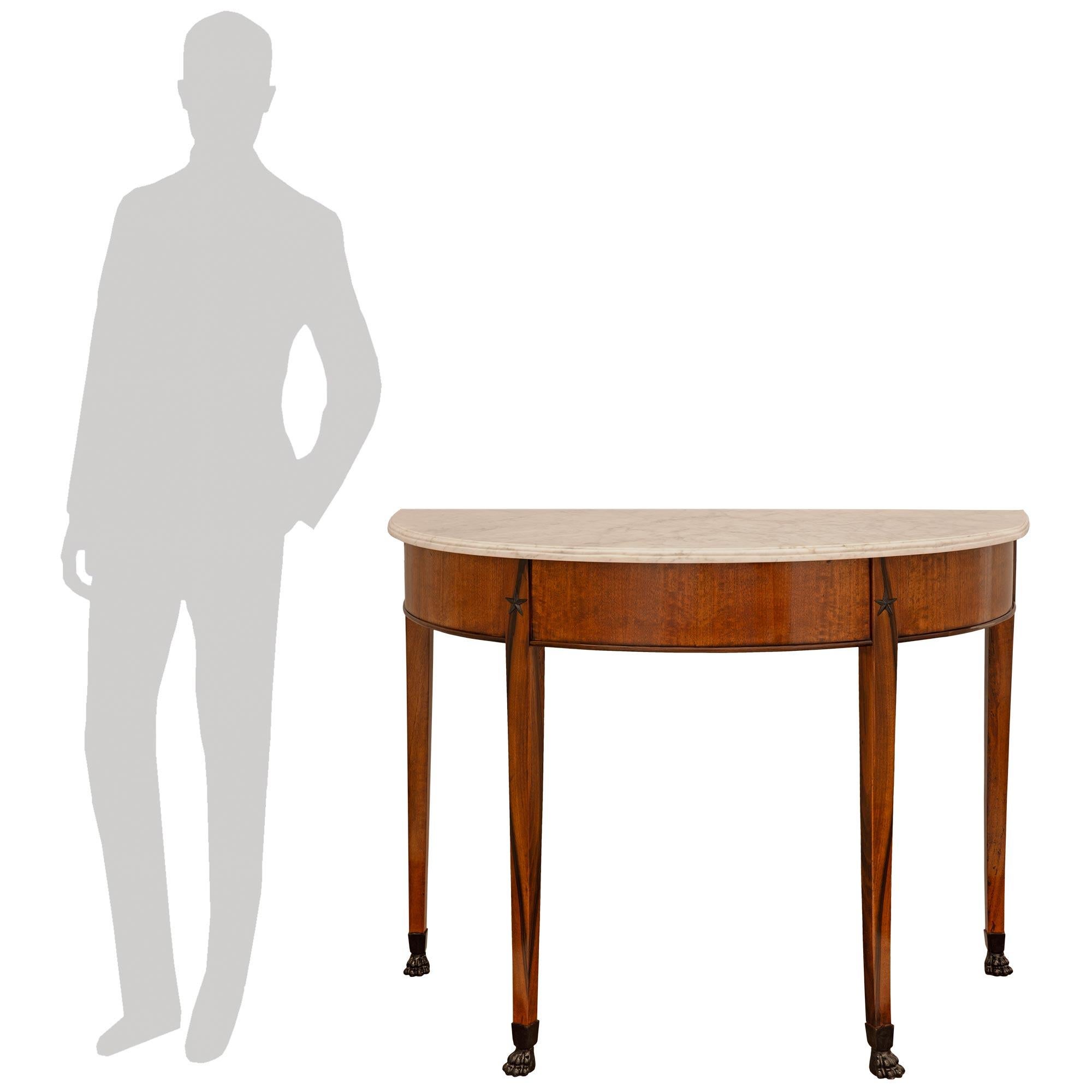 A handsome and high quality pair of Italian 19th century Neo-Classical st. Mahogany, Ebonized Fruitwood and white Carrara marble consoles. Each freestanding console is raised on four slender squared tapered Mahogany legs and supported on Ebonized