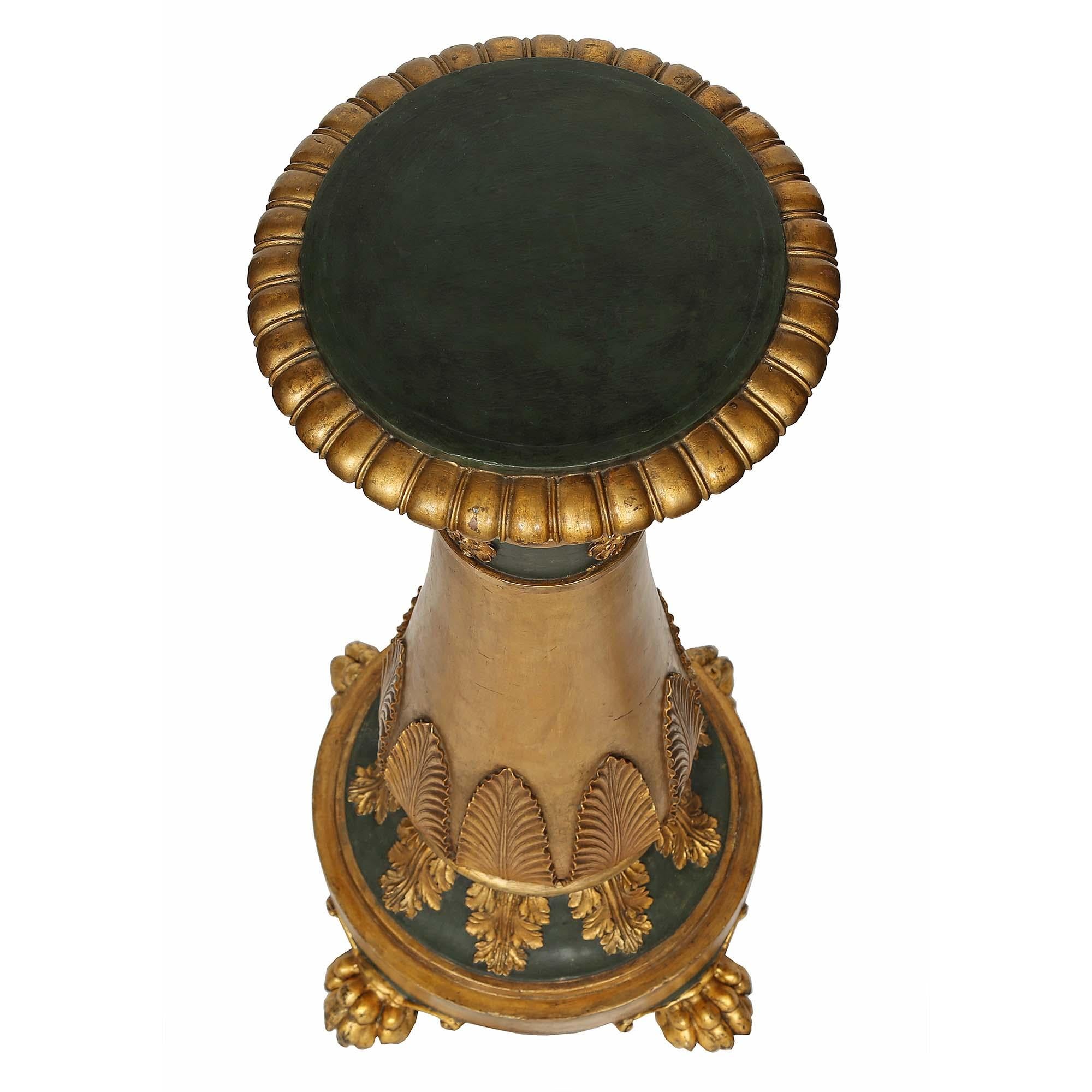 A pair of stunning Italian 19th century neo-classical st. giltwood pedestals. Each is raised on four finely carved paw feet below a circular base. The forest green patinated socle is adorned with finely carved giltwood acanthus leaves. The baluster