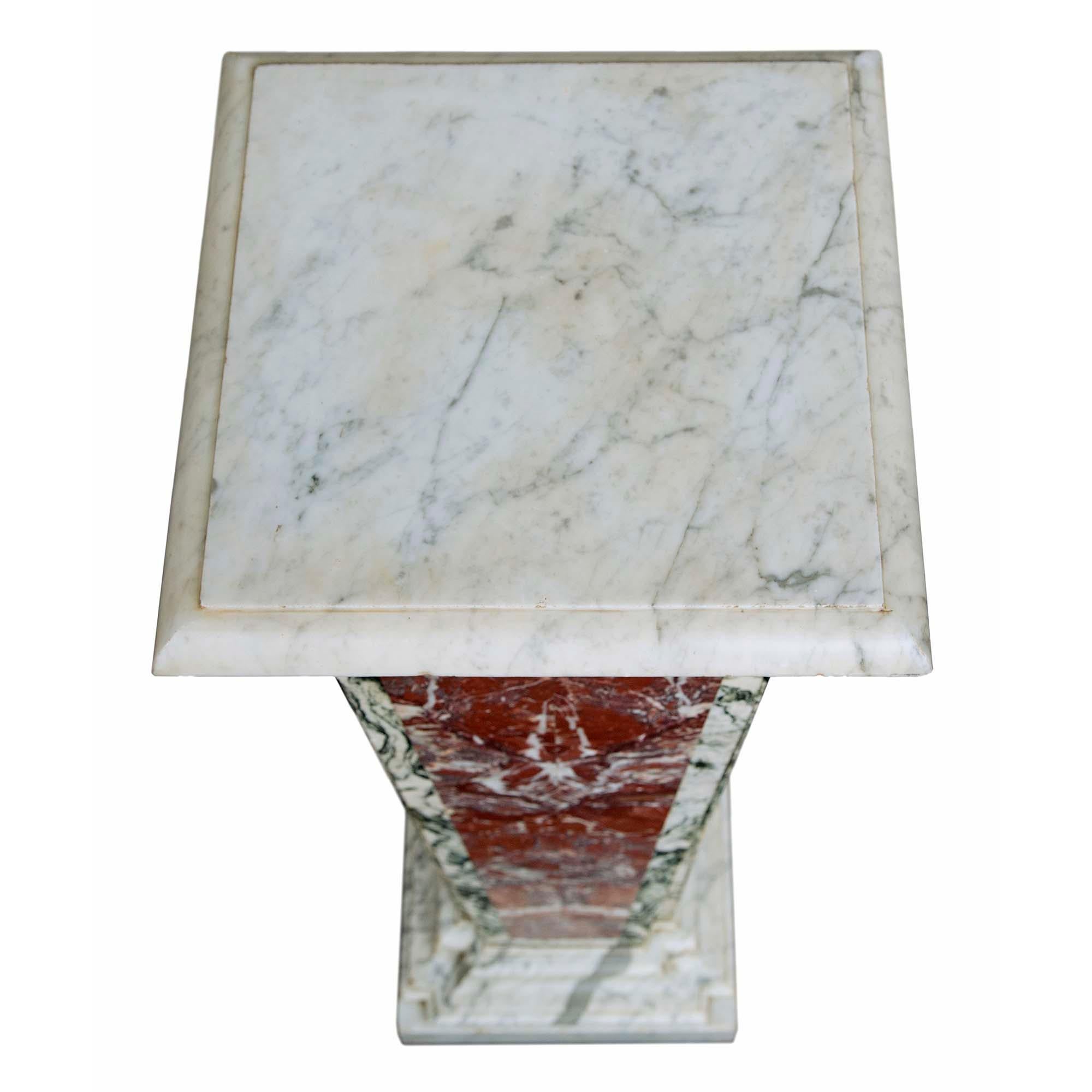 A truly stunning pair of Italian 19th century Neo-Classical st. marble pedestals. The square tapered pair of pedestals are raised by square mottled edge white Carrara marble bases. The tapered column with cut corners have a central butterfly