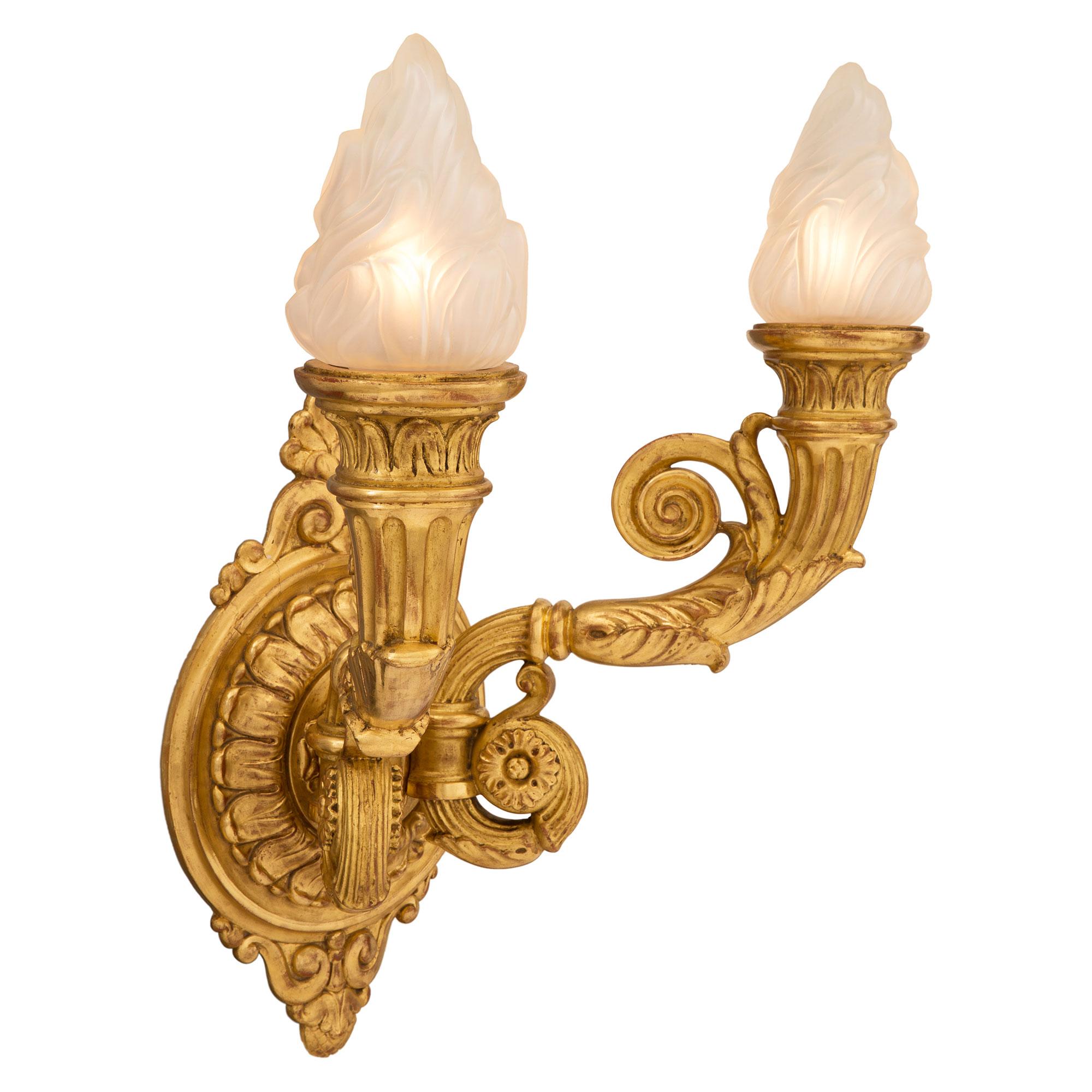 An impressive and large scale pair of Italian 19th century neoclassical St. giltwood Bras de Lumiere sconces. Each two-arm sconce is centered by a striking richly carved backplate with most decorative foliate designs, scrolled movements at the