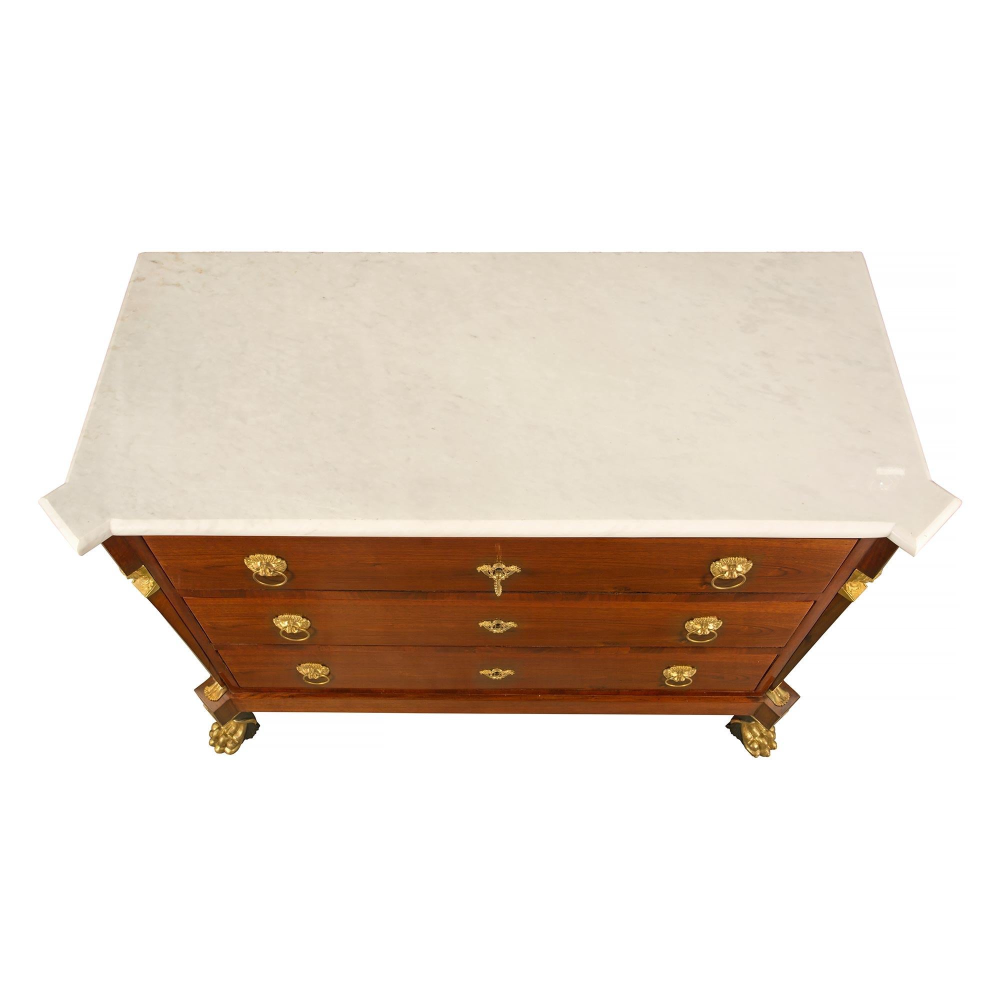A unique and extremely decorative pair of Italian 19th century Neo-Classical st. mahogany, giltwood, ormolu and marble chests. Each three drawer chest is raised by handsome and richly carved polychrome and giltwood paw feet. Above each foot are