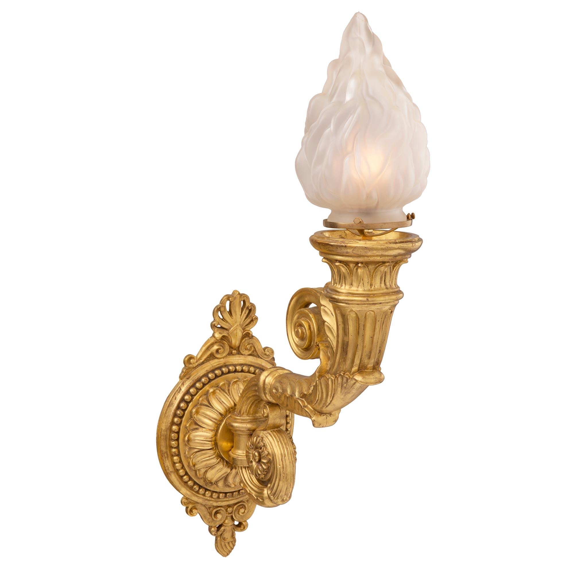 Une paire exquise et de grande taille d'appliques néo-classiques italiennes du 19ème siècle en bois doré et verre dépoli Bras de Lumière. Chaque applique présente une plaque arrière circulaire des plus décoratives avec une élégante bande perlée, des