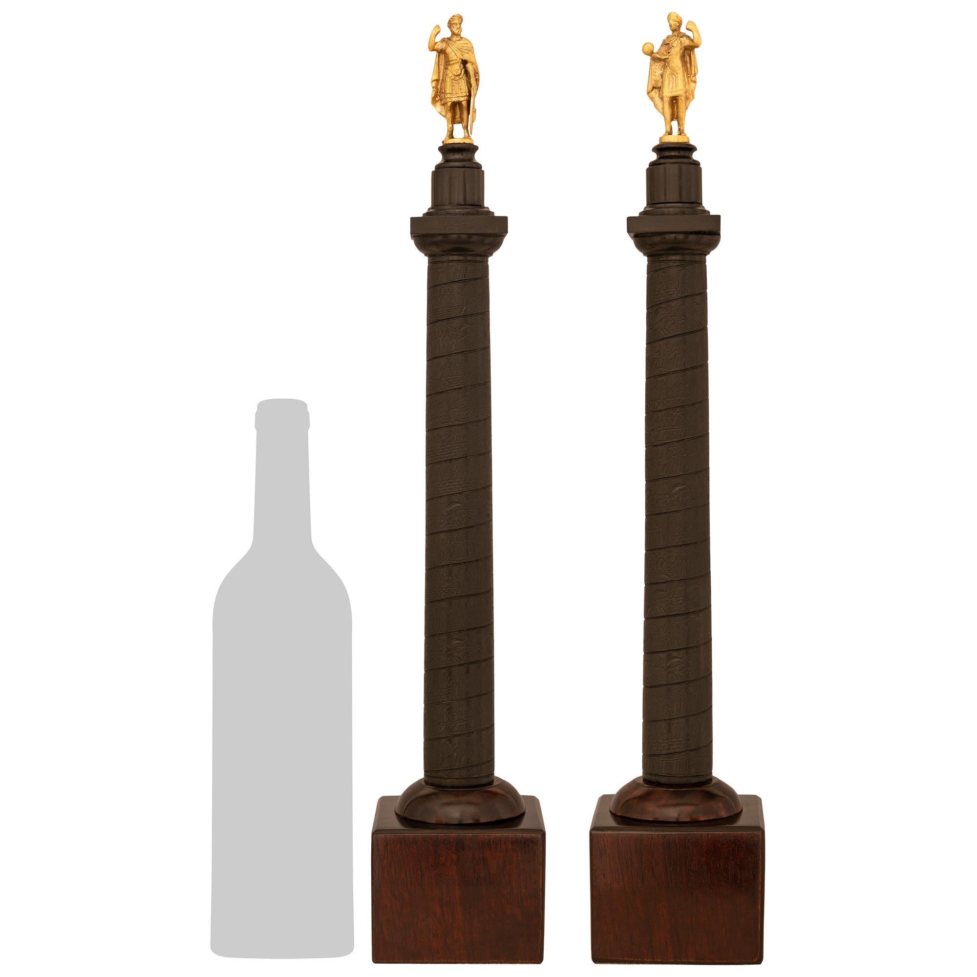 A handsome and finely detailed true pair of Italian 19th century Grand Tour period Ormolu, Mahogany, and patinated Bronze columns and statues. Each column is raised by a square Mahogany block base below the patinated Bronze column. Each patinated