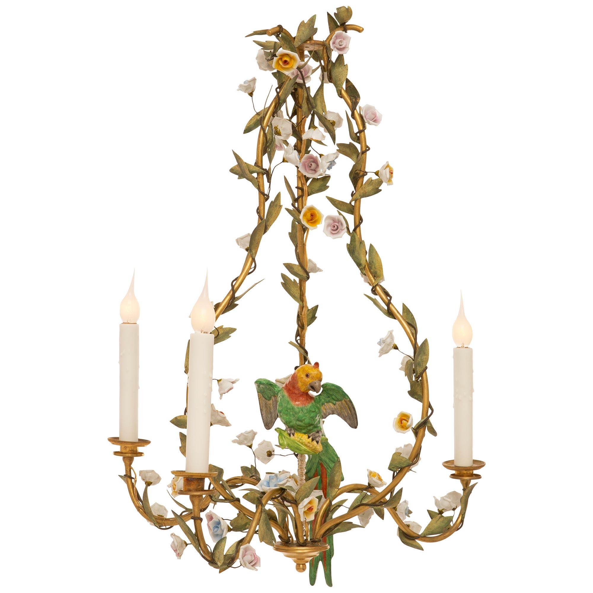 A charming and unique pair of Italian 19th century patinated Tole, Porcelain and gilt metal chandeliers. The three light three arm chandeliers display S scrolled gilt metal arms decorated with wrap around foliate branches and wonderfully colored