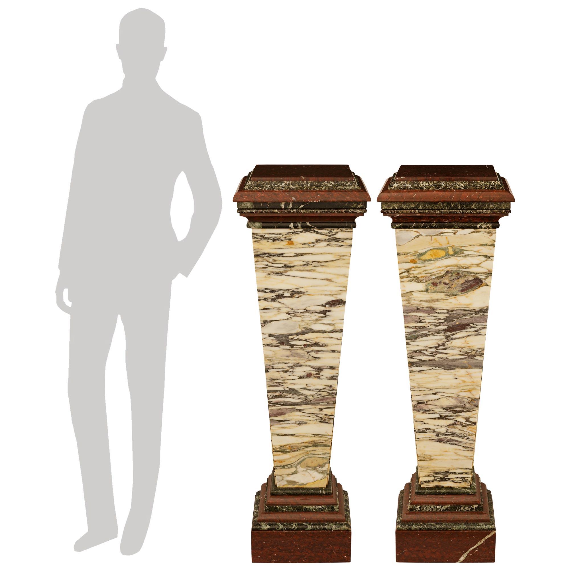 A handsome and high quality pair of Italian 19th century pedestal in various marbles. This wonderful pair of marble pedestals are raised on Rouge Griotte marble plinths below varying levels of bull nosed Verde Ranocchia and Rouge Griotte marbles.