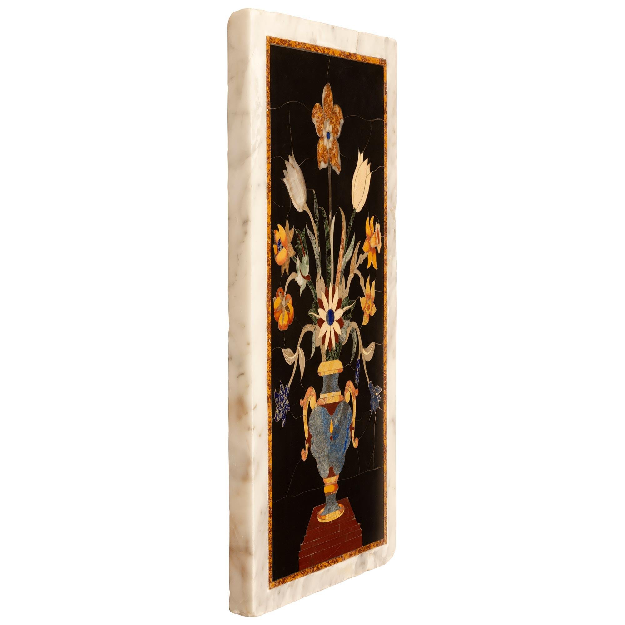 A stunning and most impressive pair of Italian 19th century Pietra Dura marble wall decor plaques. Each solid white carrara marble plaque displays exceptional intricately detailed inlaid blooming flowers in an urn with a an exquisite array of semi