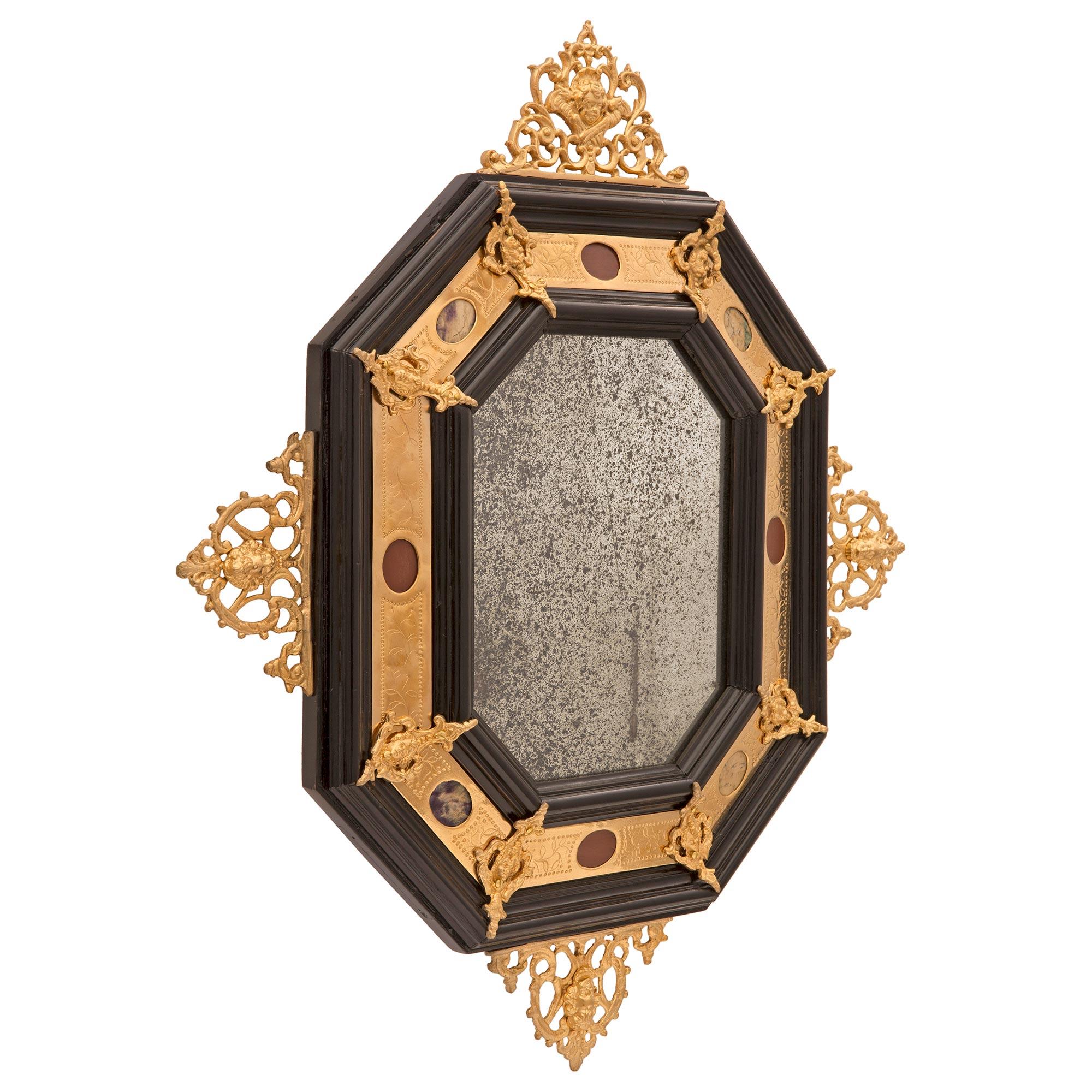 A stunning and extremely unique pair of Italian 19th century Renaissance st. Napoleon III period ebonized fruitwood, ormolu and marble inlaid mirrors. Each octagonal mirror retains its original mirror plate set within a most elegant mottled