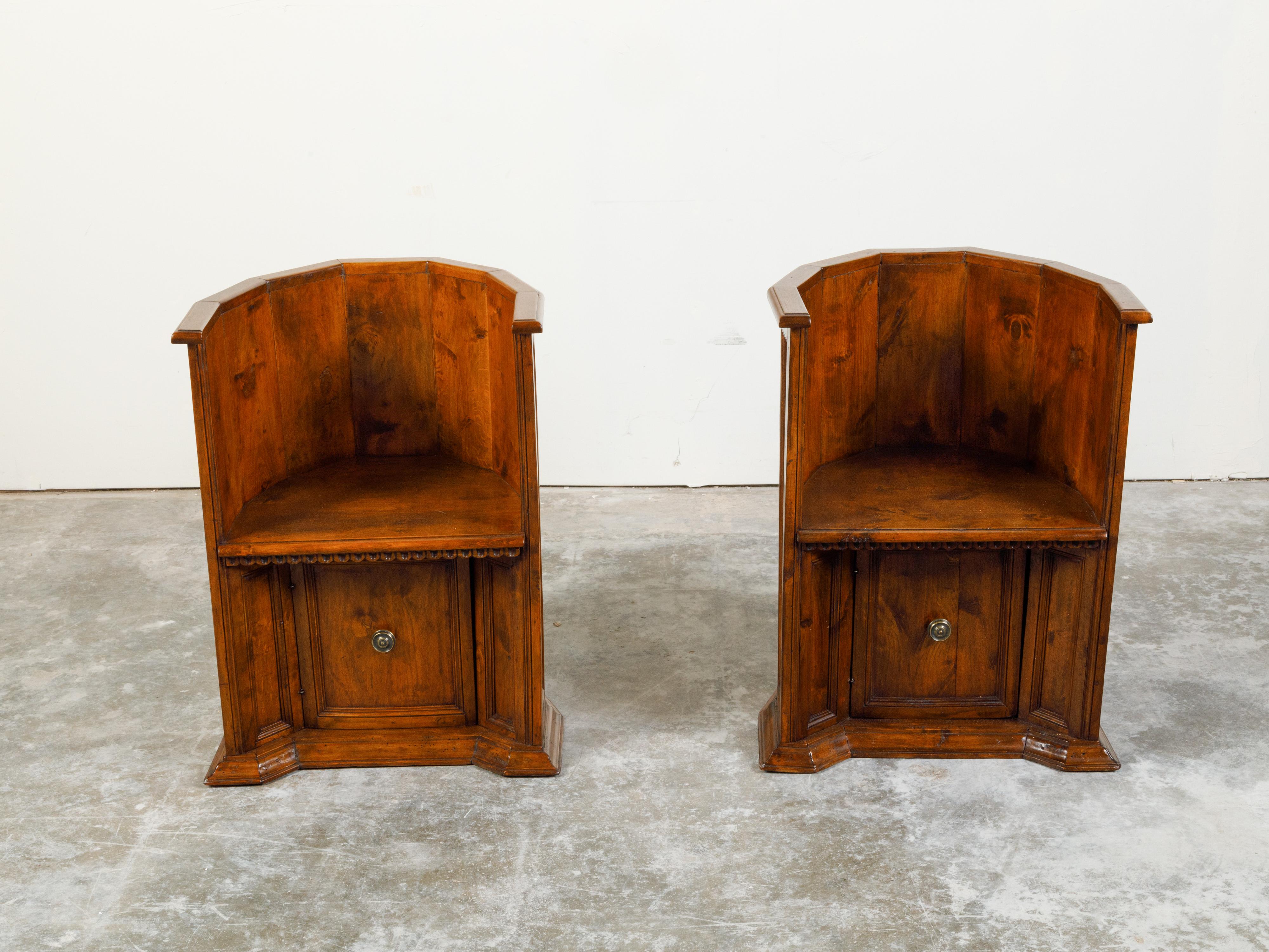 A pair of Italian Renaissance style wooden chairs from the 19th century, with solid wraparound backs, scoop motifs and lower doors. Created in Italy during the 19th century, each of this pair of chairs brings us back to Renaissance times and