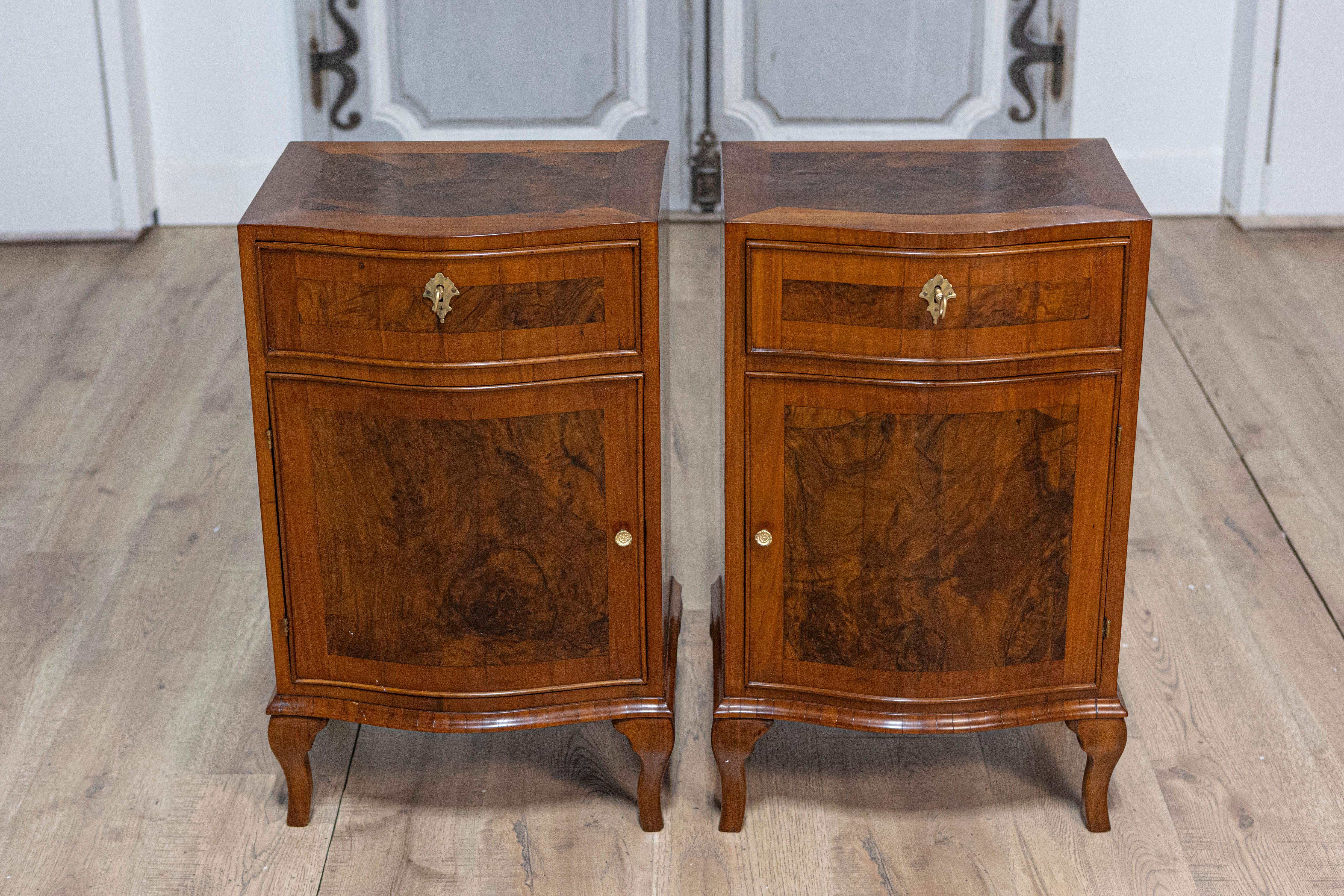 A pair of Italian bedside tables from the 19th century with burled walnut accents and single drawer over single door. Born in Italy during the 19th century, this exquisite pair of bedside tables features a harmonious mix of walnut and burled walnut,