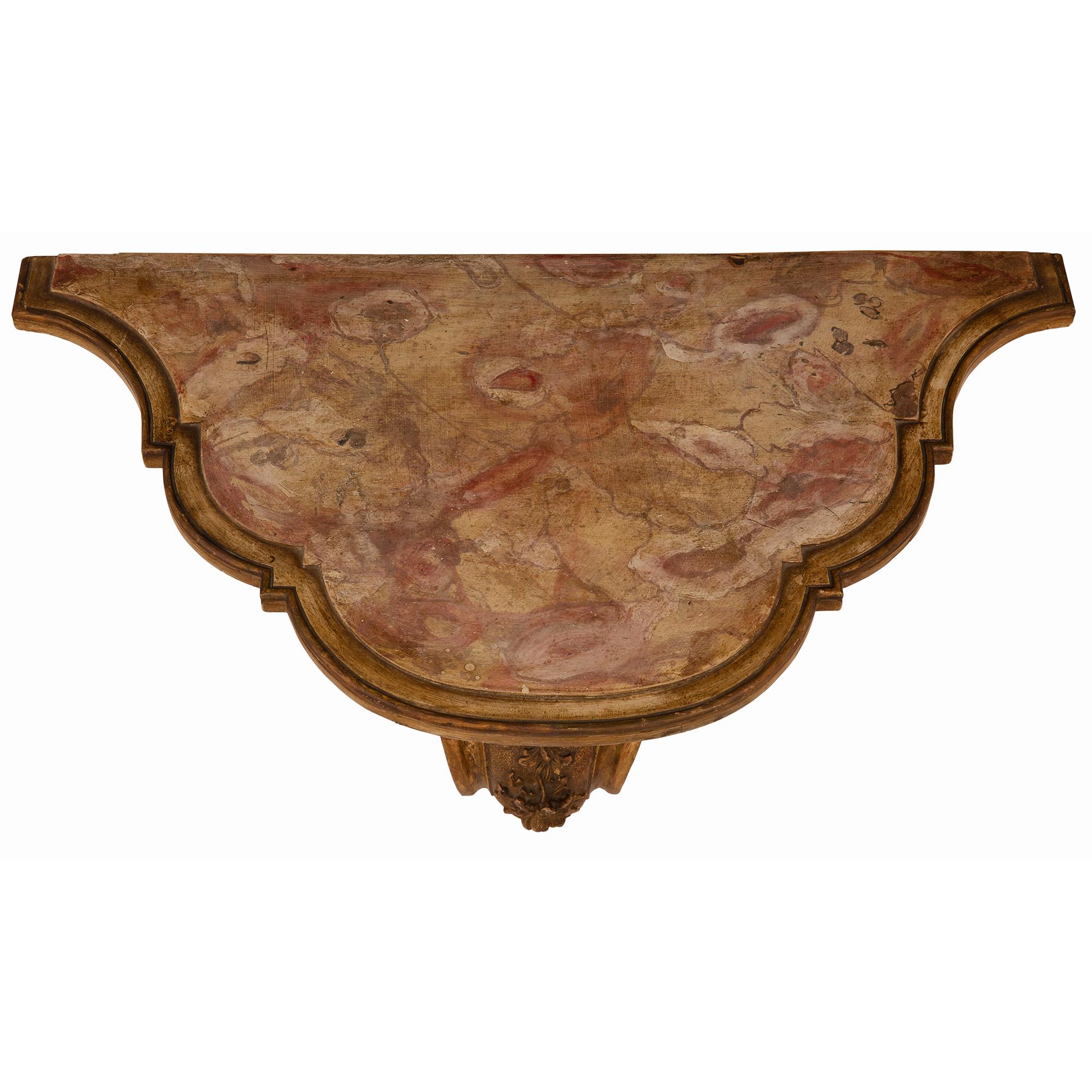 A striking pair of Italian 19th Century Venetian Mecca and faux painted wall brackets. Each wall bracket is raised by a large beautiful scrolled back support with luxuriant foliate movements. A lovely hammered design extends throughout leading