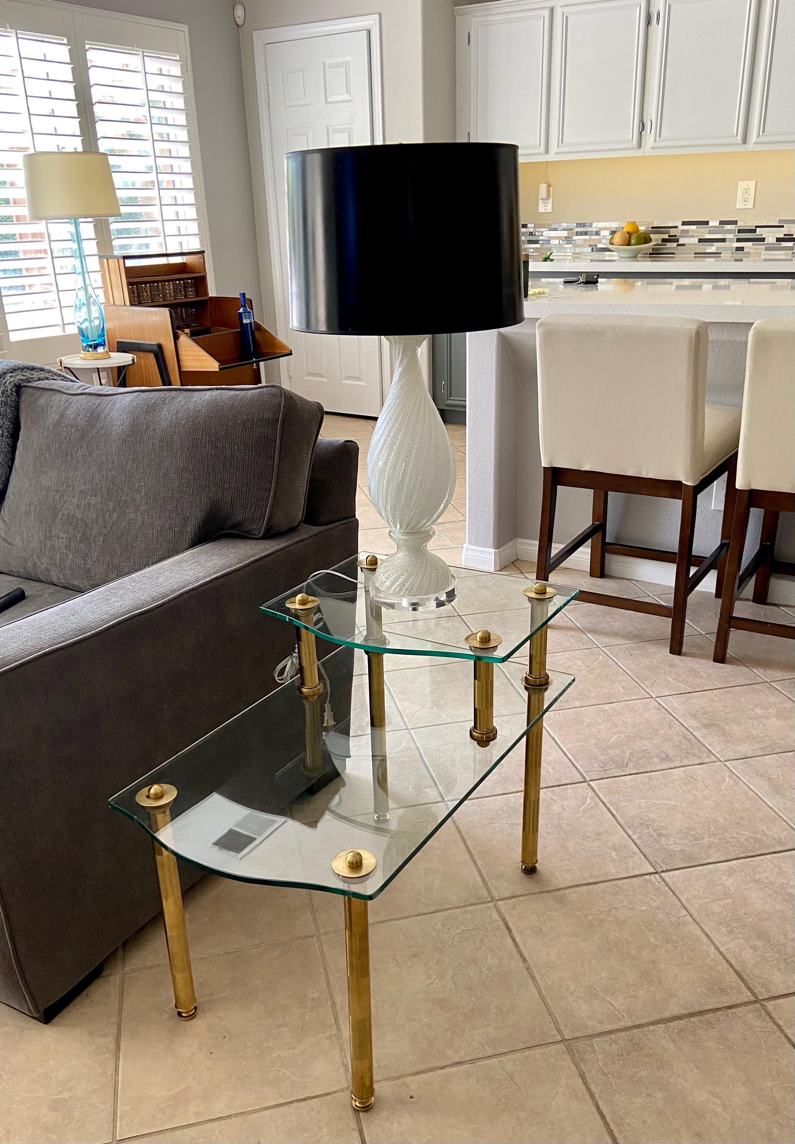 A pair of Italian two step tier side tables with glass shelvers attached to brass legs and fittings.. The solid brass fittings and cylinder shape legs (not plated) are high quality. Legs are done in 2 tone finish, alternating matte and gloss. Very