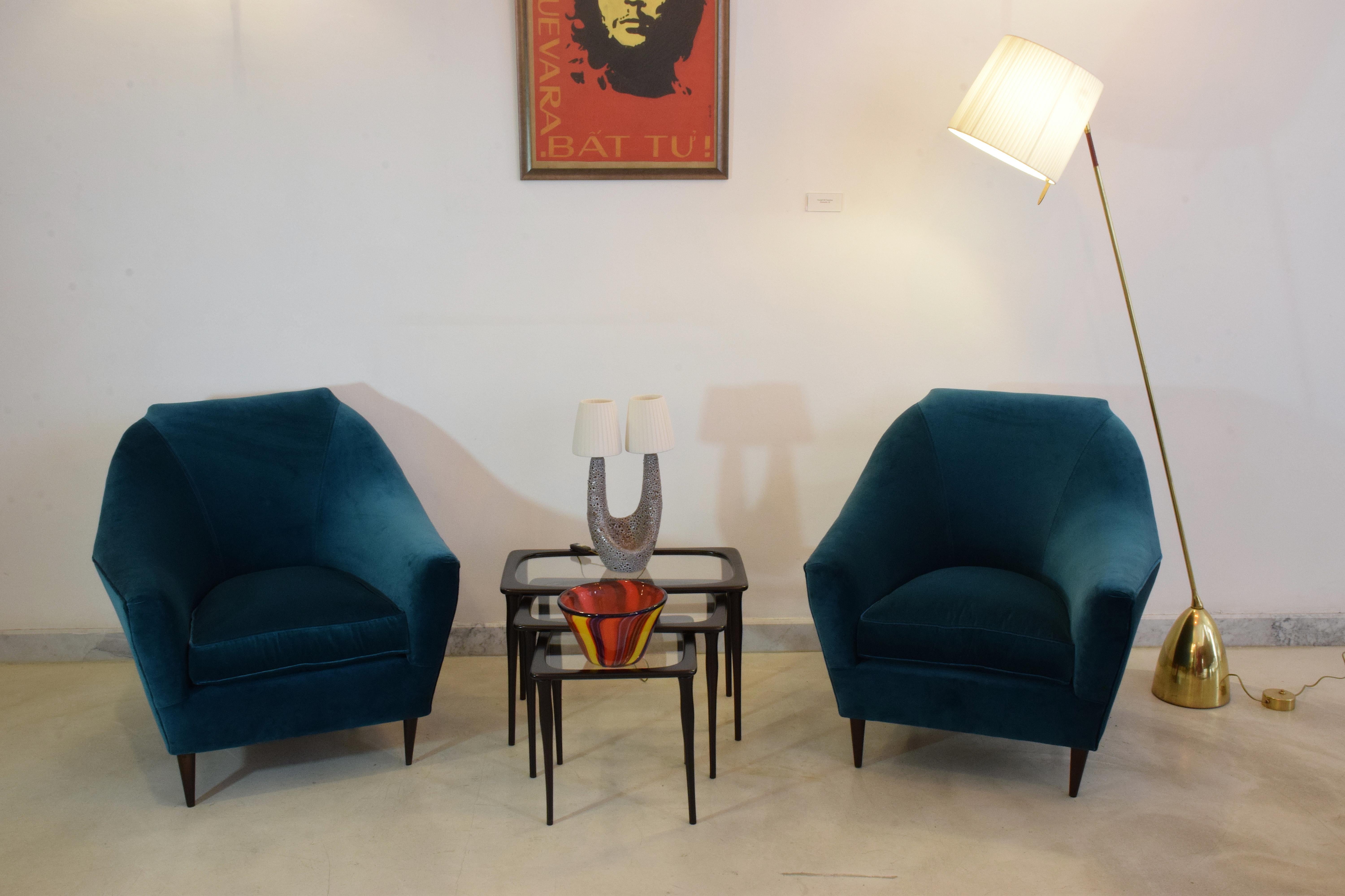 A rare set of two Italian midcentury collectible armchairs or lounge chairs designed by Ico Parisi at the beginning of the 1950s. The angular shape of the backrest and cone-shaped wooden feet are an Italian design staple of the period.
In fully