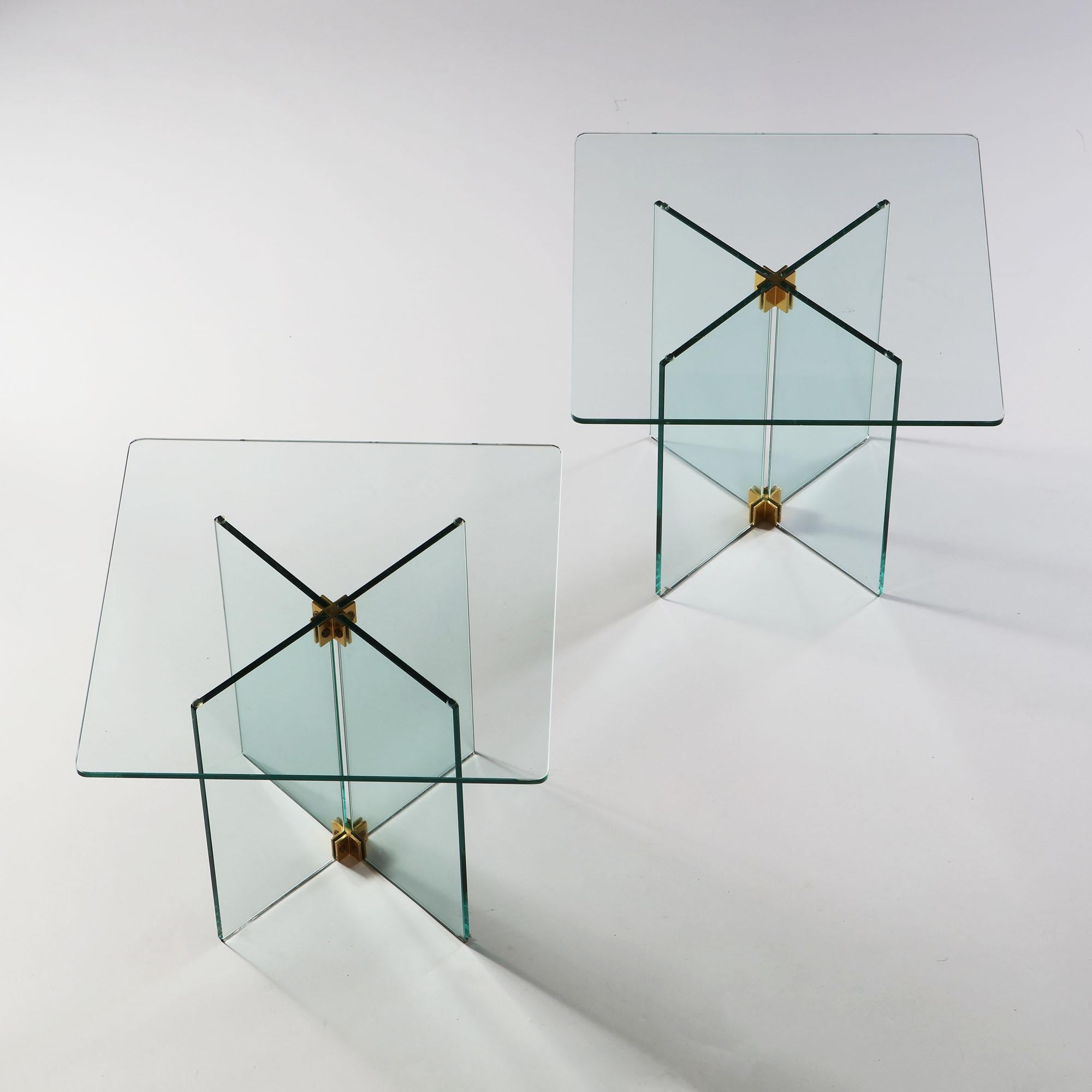A pair of X frame glass occasional tables with brass hinge mounts, after Fontana Arte.