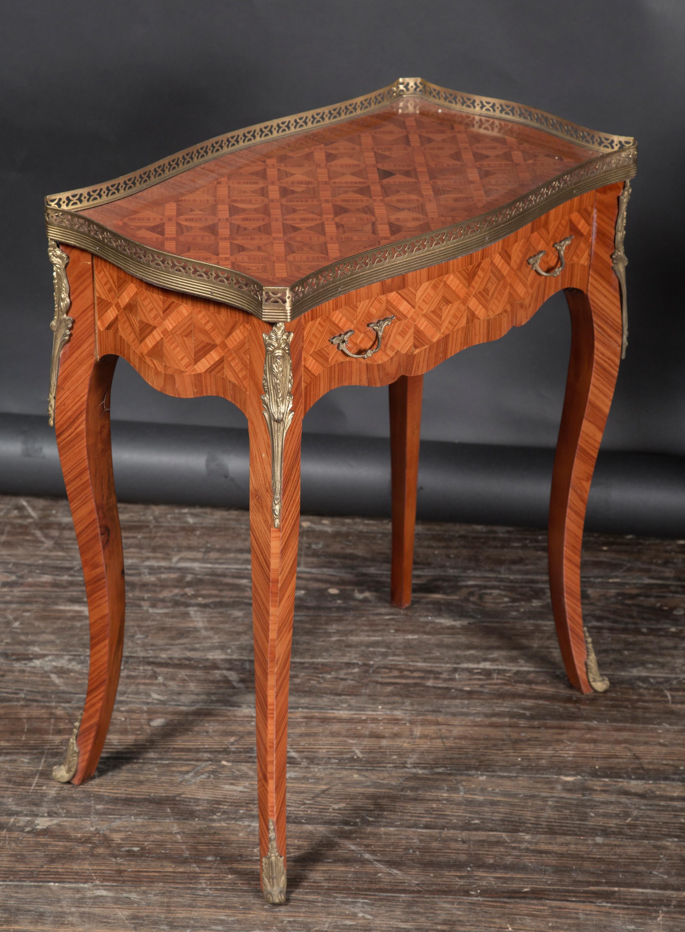 Dieses schöne Paar Tische aus satiniertem Holz im Louis-XV-Stil stammt aus dem 20. Jahrhundert und hat geschwungene Cabriole-Beine, die für den Louis-XV-Stil typisch sind. Das Paar beherbergt eine netzartige Bronzegalerie im oberen Bereich,