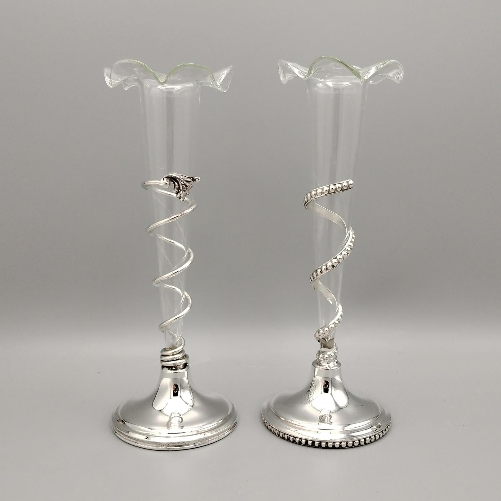 Pair of silver vases with blown glass flower holders.
One is in beaded style the other smooth
The base is round in solid 800 silver where a flat and beaded spiral border has been soldered on one and a smooth round border on the other.
This spiral