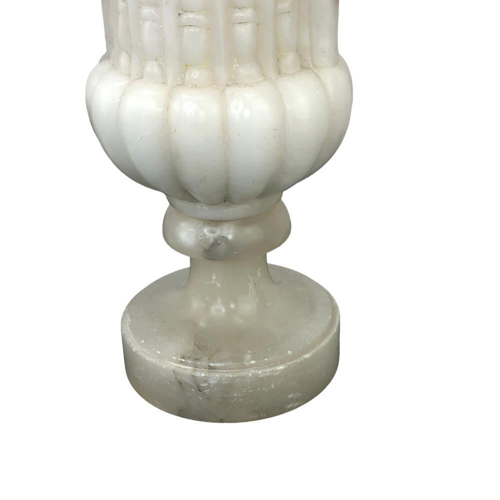 Pair Of Italian Alabaster Carved Urn Lamps. Expertly hand crafted from Italian alabaster with intricate detailing. Each carved urn with a flared fluted urn and scrolling handles. Newly wired with a 3-way socket.