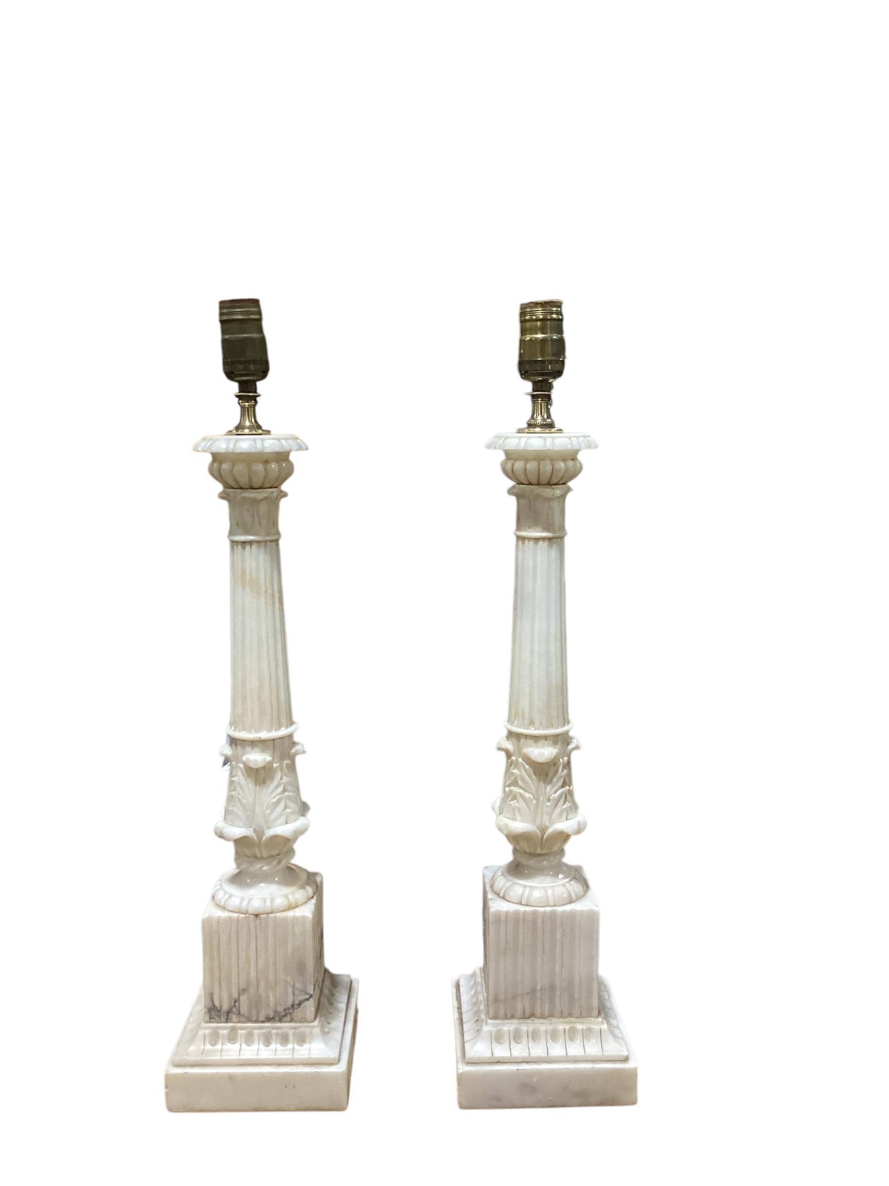 Paar italienische Alabaster-Säulenlampen mit korinthischen Kapitellen. Handgeschnitzt mit geriffelten Säulen und einem quadratischen Sockel. Die Lampen wurden neu verkabelt und haben neue Steckdosen. Sie messen 21