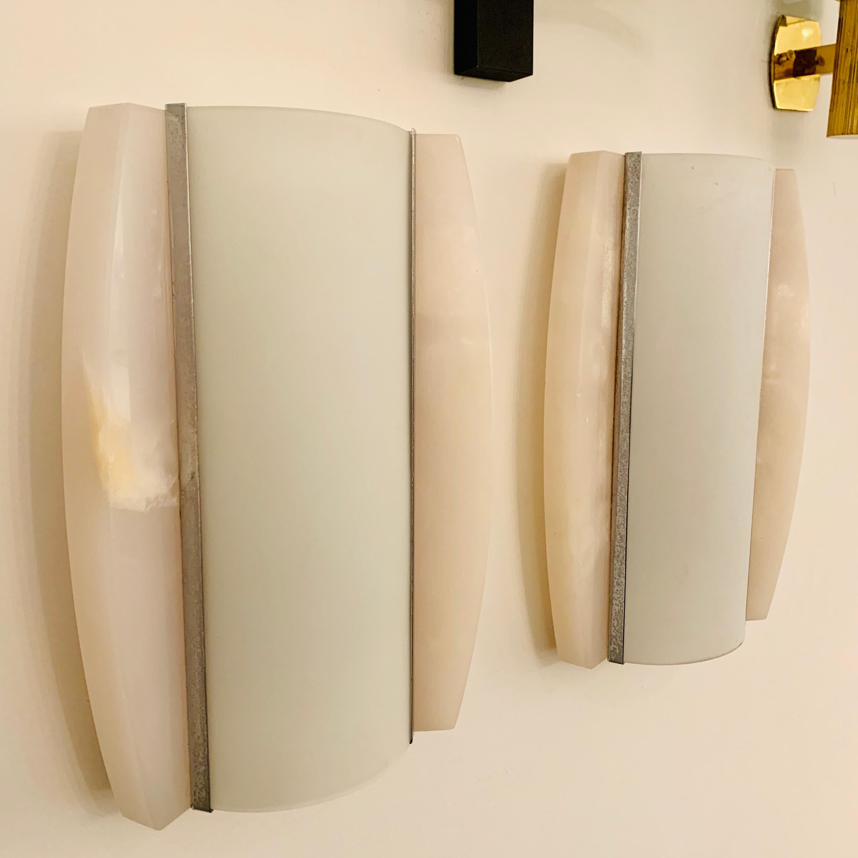 A sleek pair of 1960s Italian Space Age wall lights composed of alabaster decorative elements and milk white glass shades. Rewired.