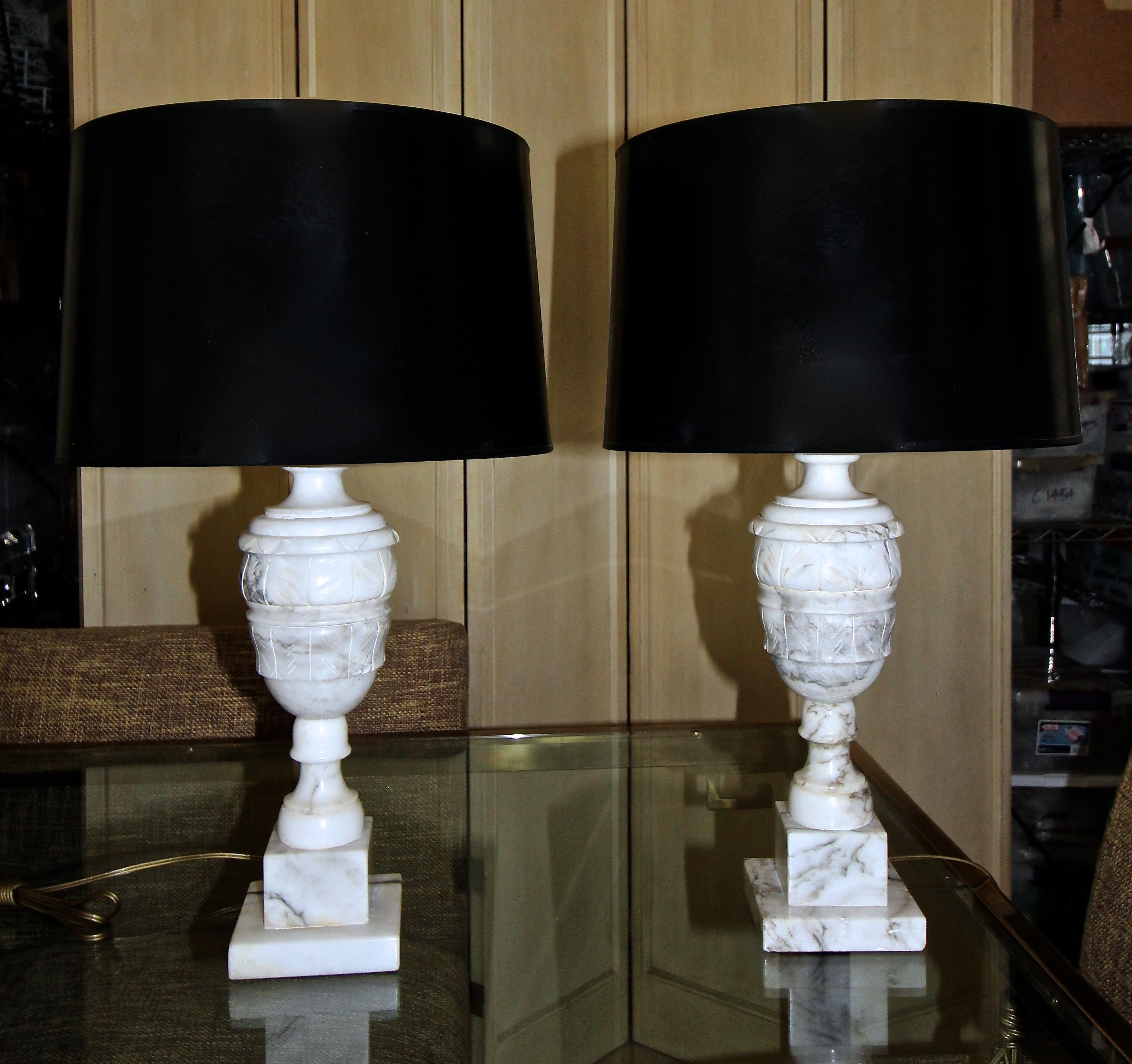 Pair of Italian neoclassic style alabaster table lamps with brass fittings. Newly rewired with 3 way socket and gold cord. Includes original alabaster matching harp finials. Shades not included for photography purposes only.
