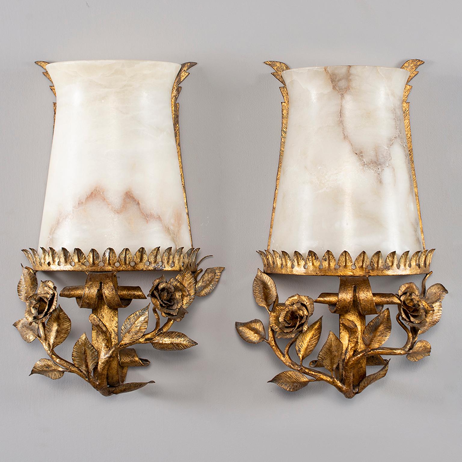 Pair of Italian sconces have metal bases depicting sculpted roses and leaves with a gilt finish and alabaster globes, circa 1940s. Each sconce has a single candelabra sized socket. Electrical wiring has been updated for US standards. Sold and priced