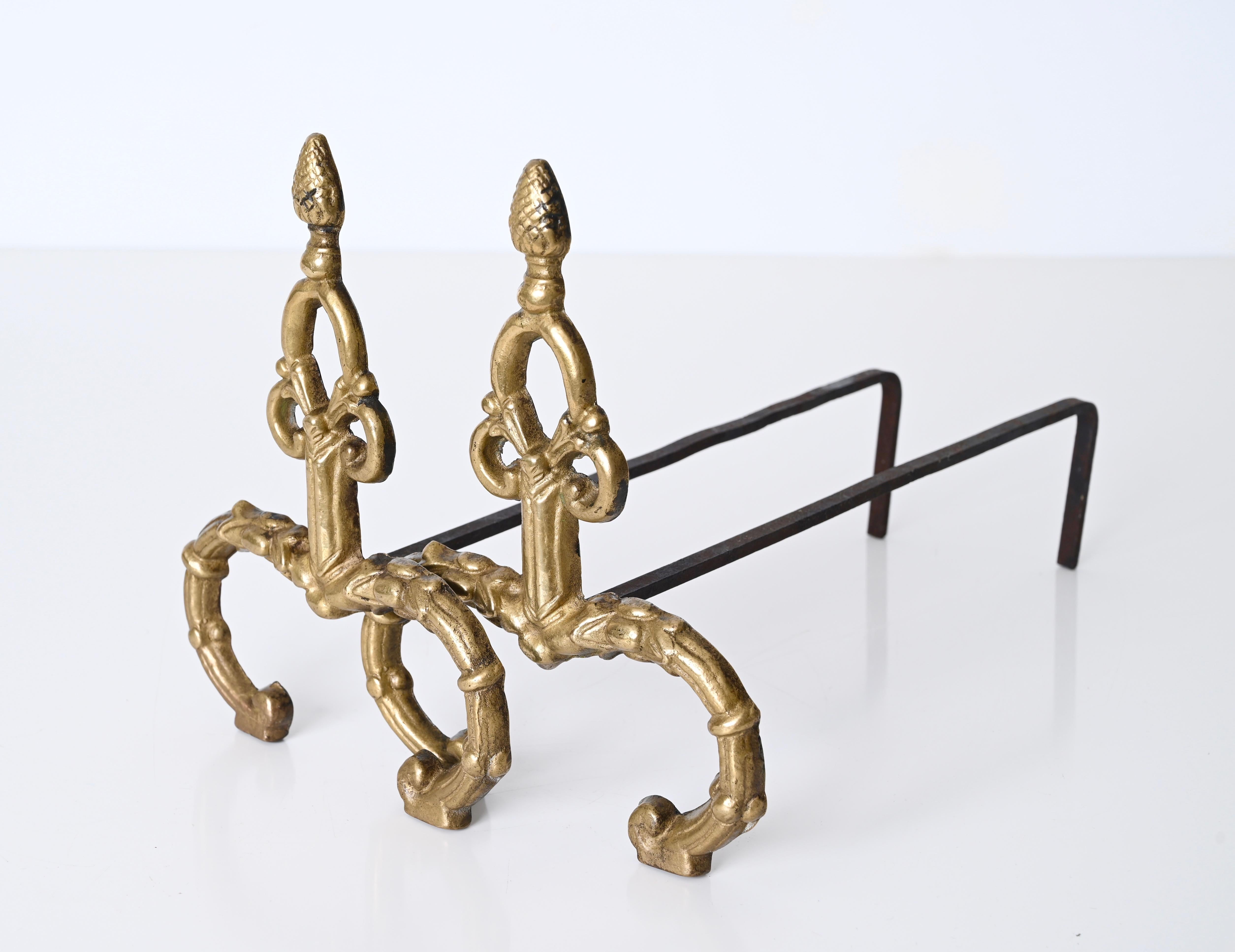 Precious pair of andirons in gilded bronze and forged iron in Louis XV style. These stunning firedogs were made in Italy in the 1940s.

The front of these andirons is made in forged gilt bronze with fantastic details, the top reproduce a pinecone