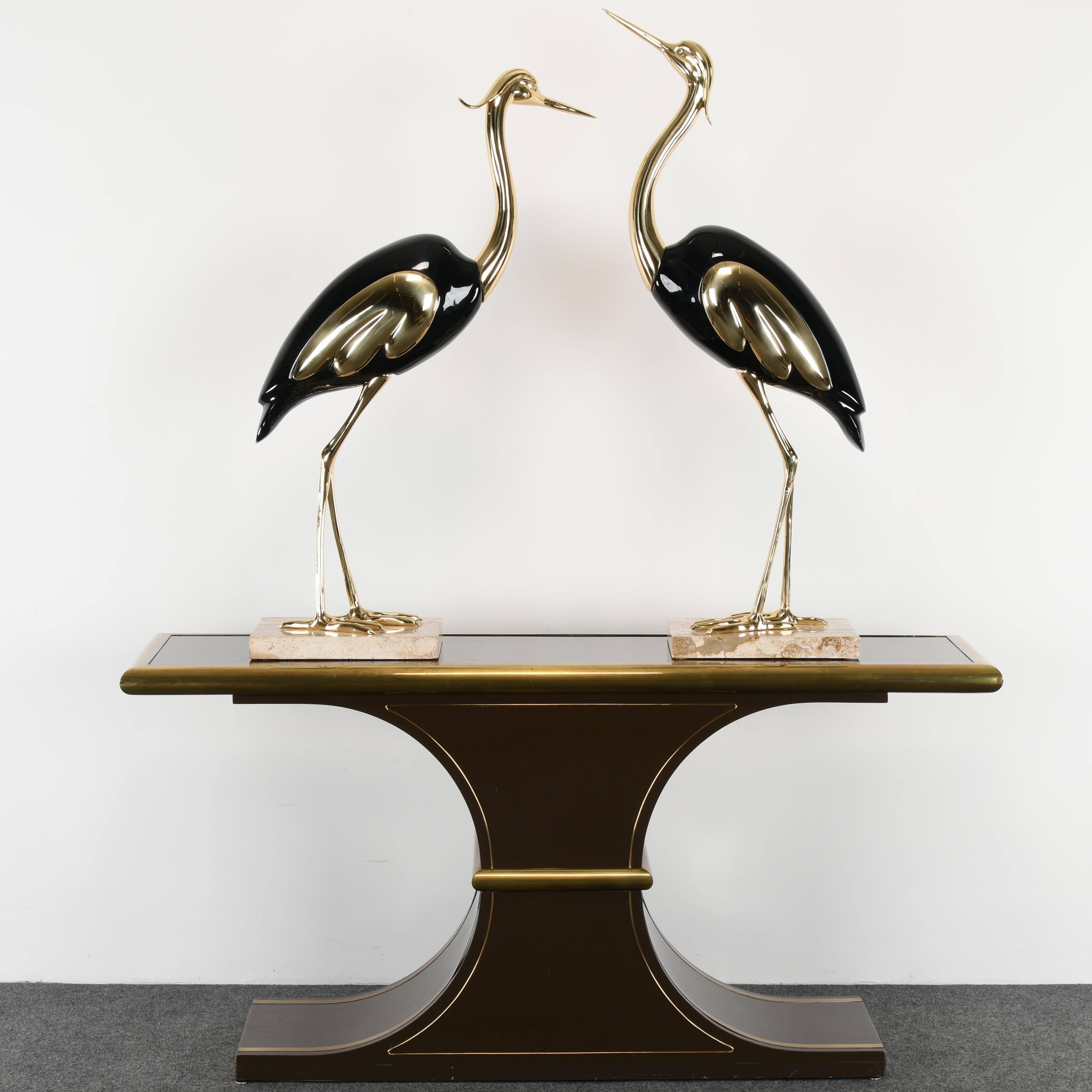 A pair of Italian Antonio Pavia style brass and black lacquer Italian egrets or cranes on a travertine base. Egrets are in very good condition. Stamped 