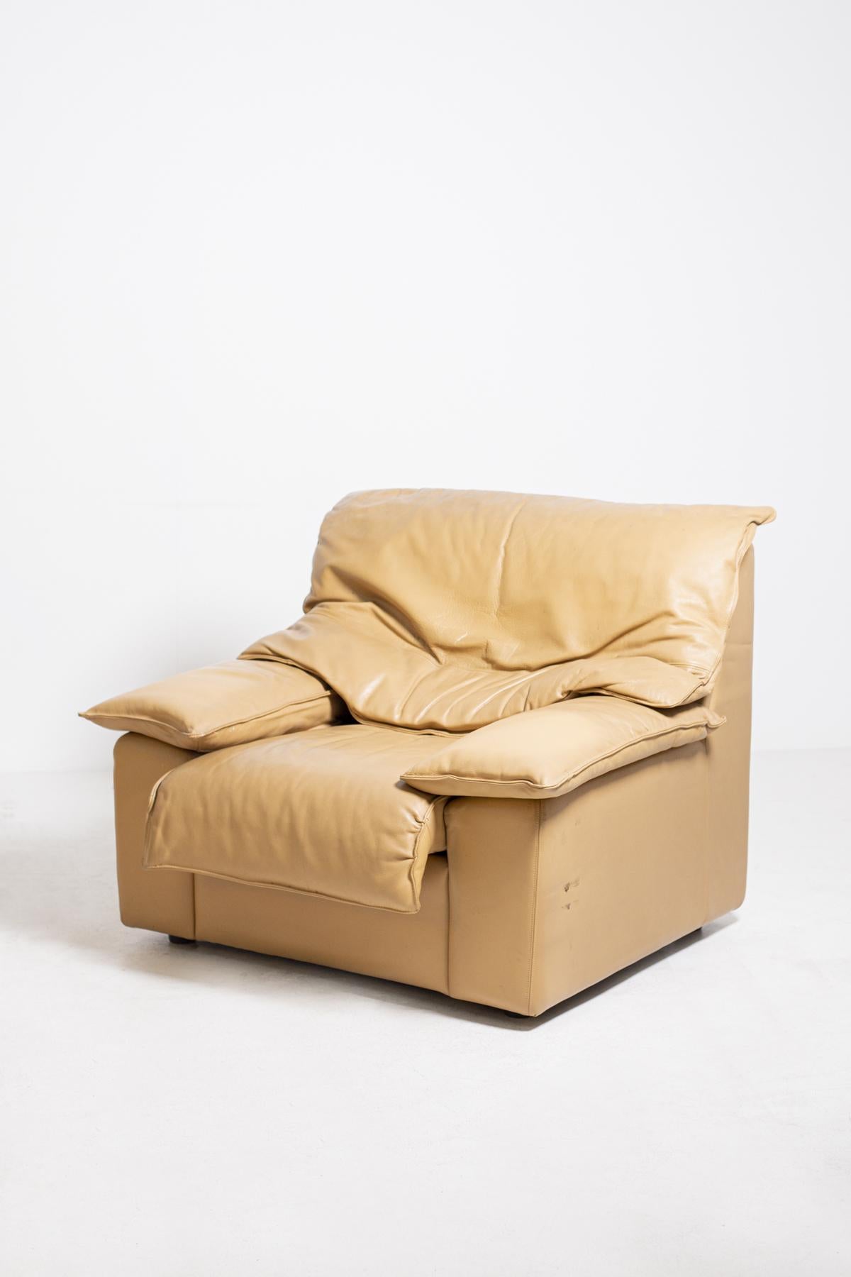 Paire de fauteuils de fabrication italienne des années 1970. Les fauteuils, de par leur grande taille, sont idéaux pour meubler des salons modernes ou contemporains. Elles sont fabriquées en cuir de couleur camel. Ses doubles coussins enveloppent