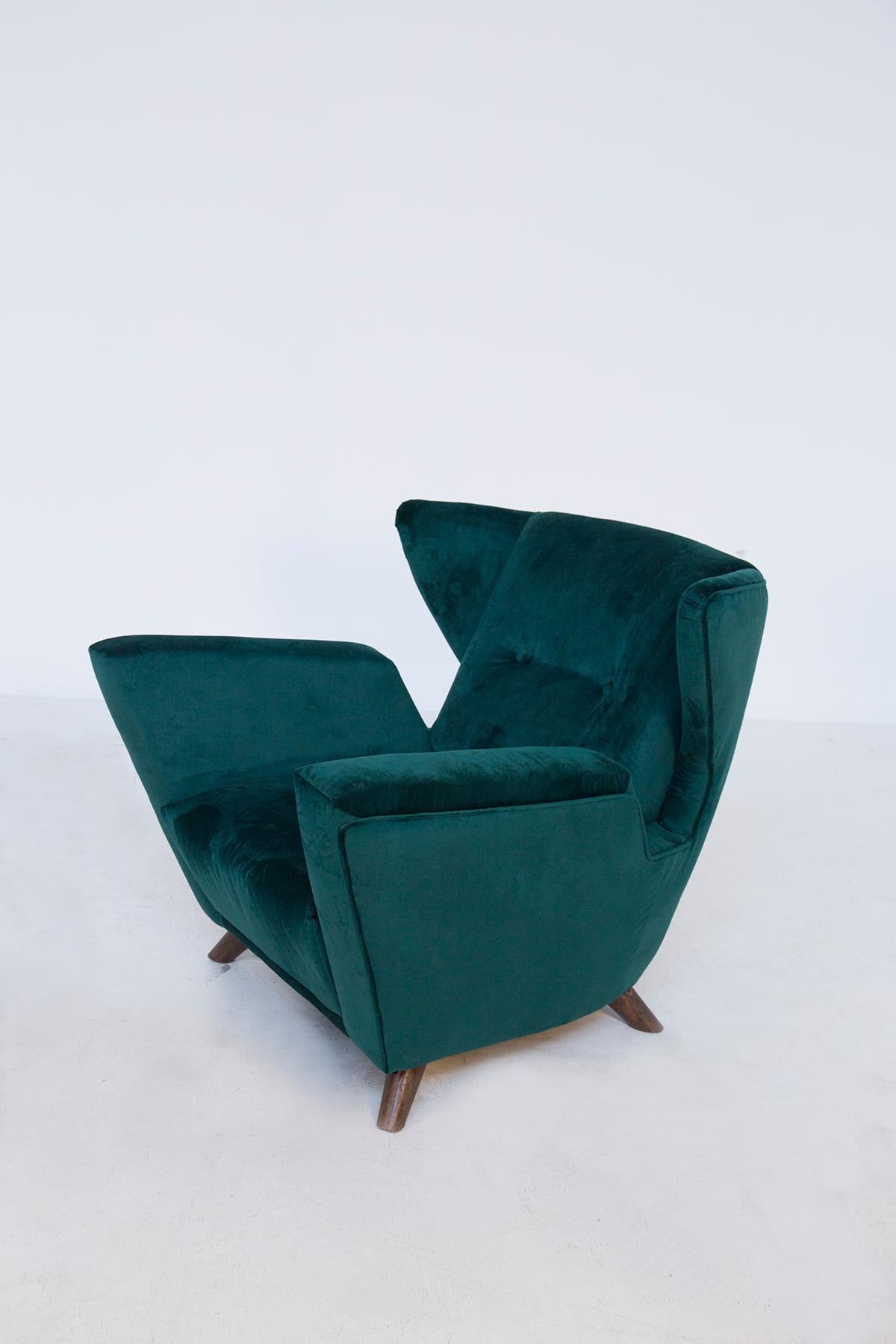 Pair of Italian armchairs attributed to Gio Ponti for the Ships. The armchairs have been restored in an elegant green velvet. The beauty of the armchair is given by its geometric shapes or with pointed volumes, almost its armrests turning upwards.