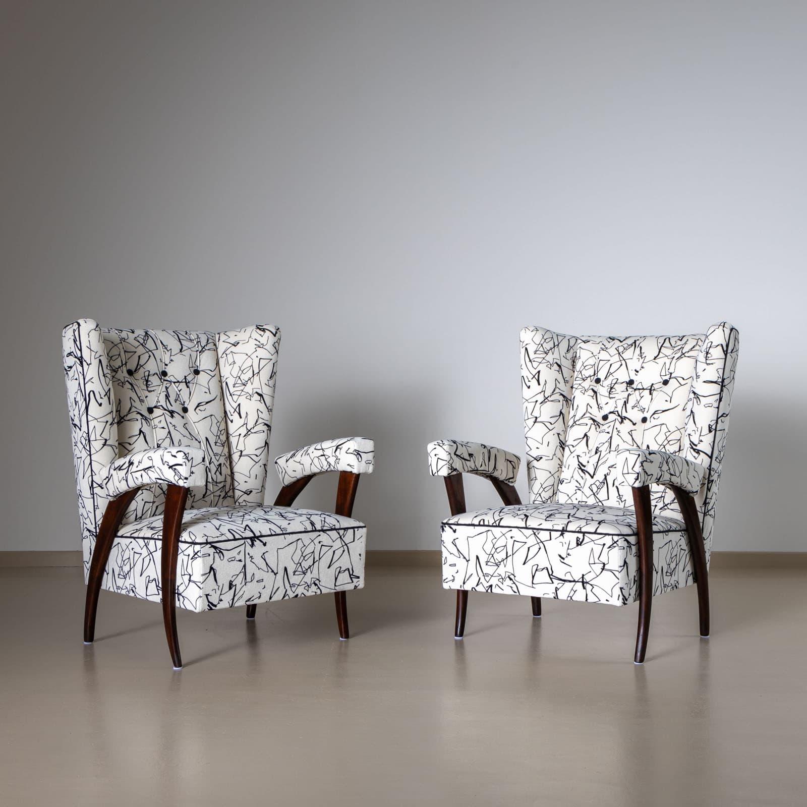 Coppia di sedie lounge italiane con schienale trapezoidale e ampio e braccioli imbottiti. Le poltrone poggiano su gambe affusolate e ricurve in legno tinto scuro. Le poltrone sono state rivestite e imbottite di recente. 